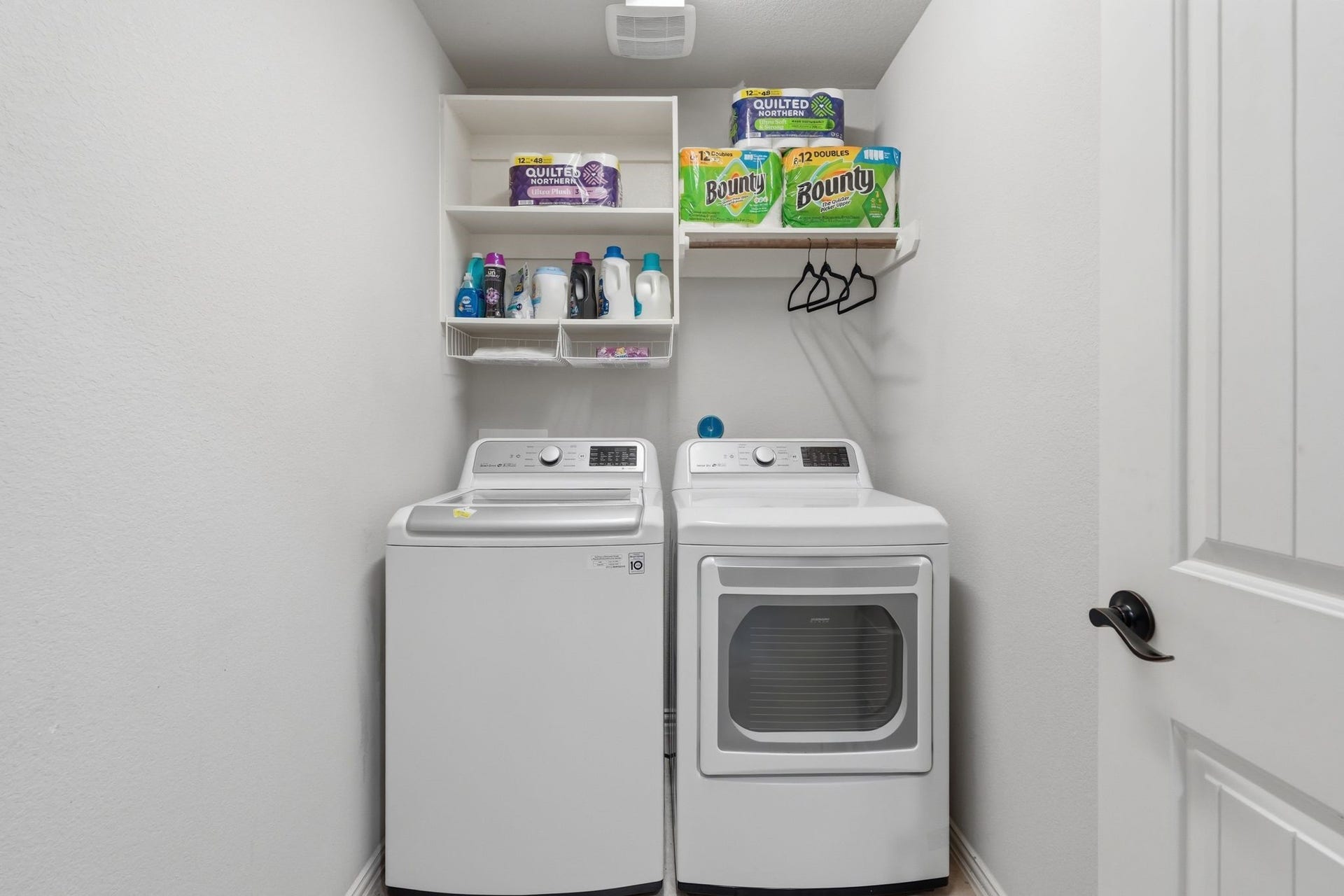 Laundry room with built-in shelving and hanging bar.