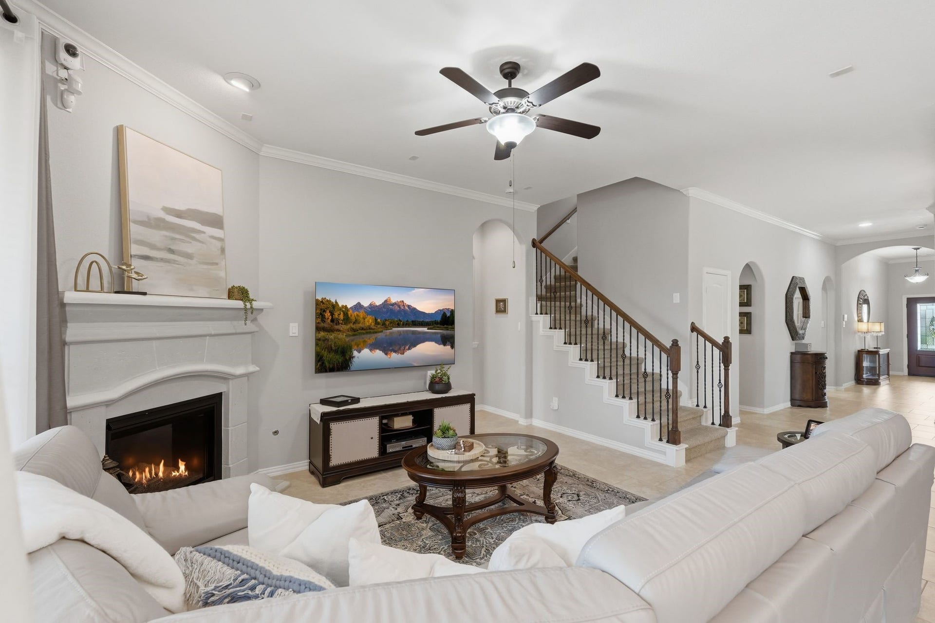 The living room features a gas log fireplace and classic white mantle.