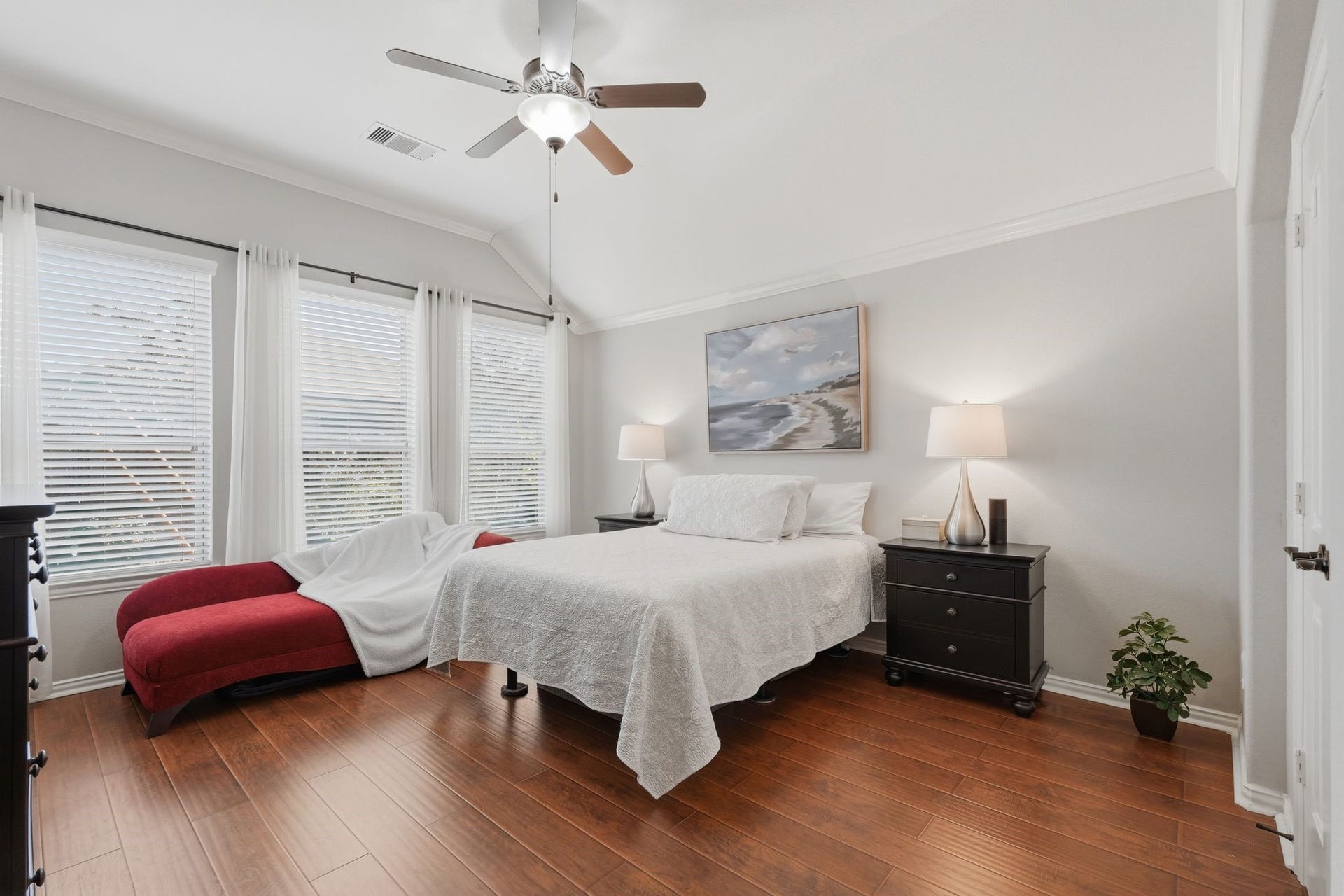 The Primary Suite features hardwood flooring, picture windows, and light neutral paint.