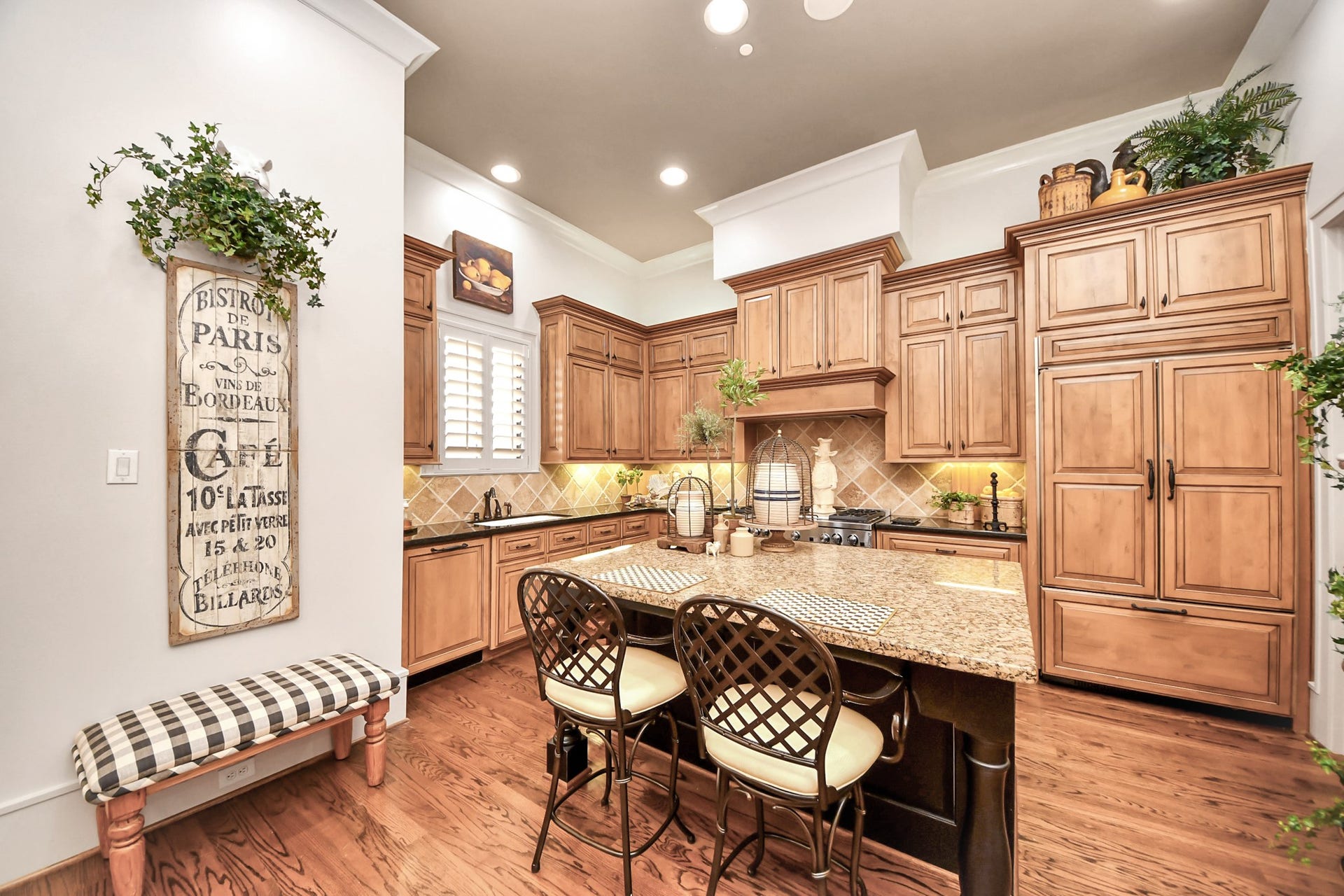 1406 Lake Pointe Parkway, Sugar Land, TX 77478 The chefs kitchen showcases Benedettini cabinetry, a walk in pantry, and an oversized island with turned legs. Professional appliance package also features under counter microwave and warming tray.