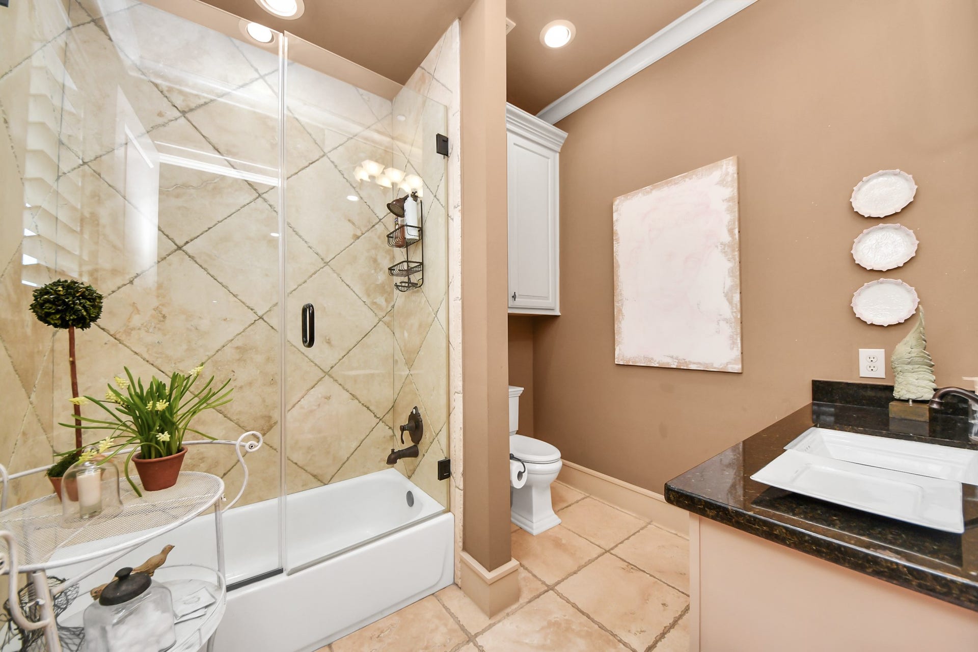 1406 Lake Pointe Parkway, Sugar Land, TX 77478 Well-appointed guest bath is en suite, featuring a granite vanity, oil-rubbed bronze fixtures, and a glass-enclosed shower. Clean lines and quality finishes create a refined, comfortable space for visitors.