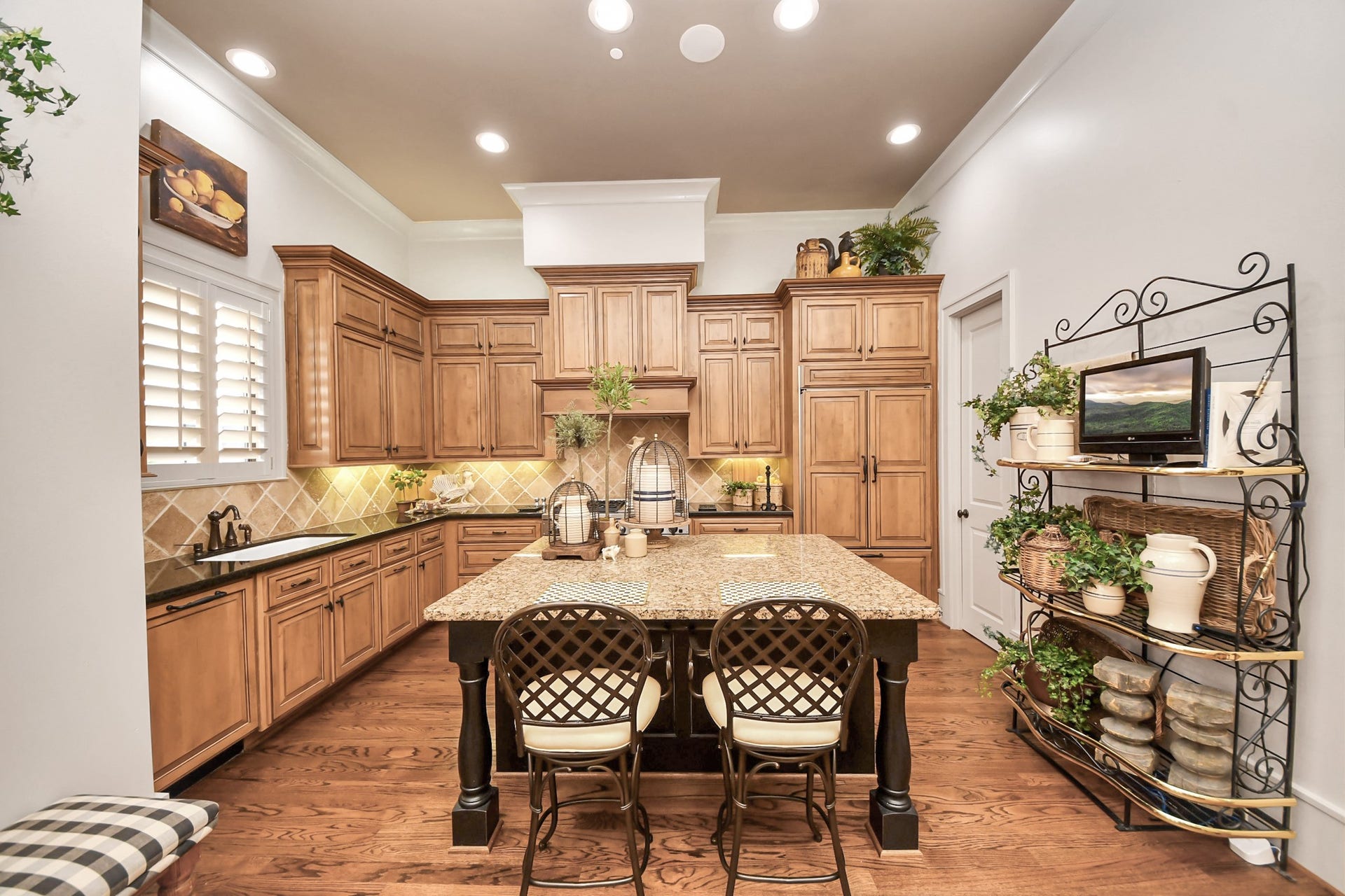 1406 Lake Pointe Parkway, Sugar Land, TX 77478 Central island anchored by granite surfaces and professional-grade gas range, complemented by under-cabinet lighting and custom millwork.