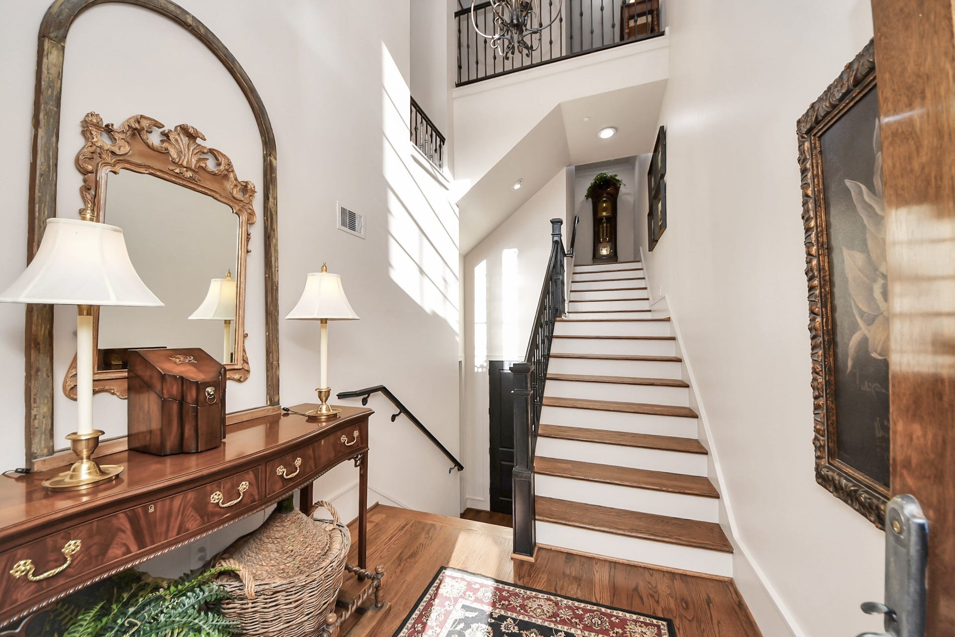 1406 Lake Pointe Parkway, Sugar Land, TX 77478 Grand two-story entry featuring an overlook from the upper level and a wood staircase with iron railing that immediately anchors the space.