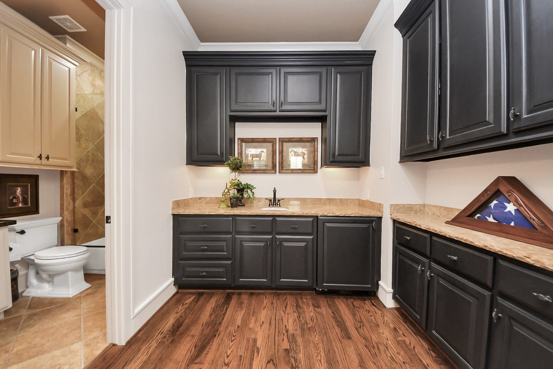 1406 Lake Pointe Parkway, Sugar Land, TX 77478 Custom service area adjoining the office, appointed with custom cabinetry, granite countertops, sink, and beverage refrigerator. Designed to function seamlessly in a professional setting, this space also offers flexibility for residential use, easily transitioning to a dressing area or expanded closet for guest quarters.