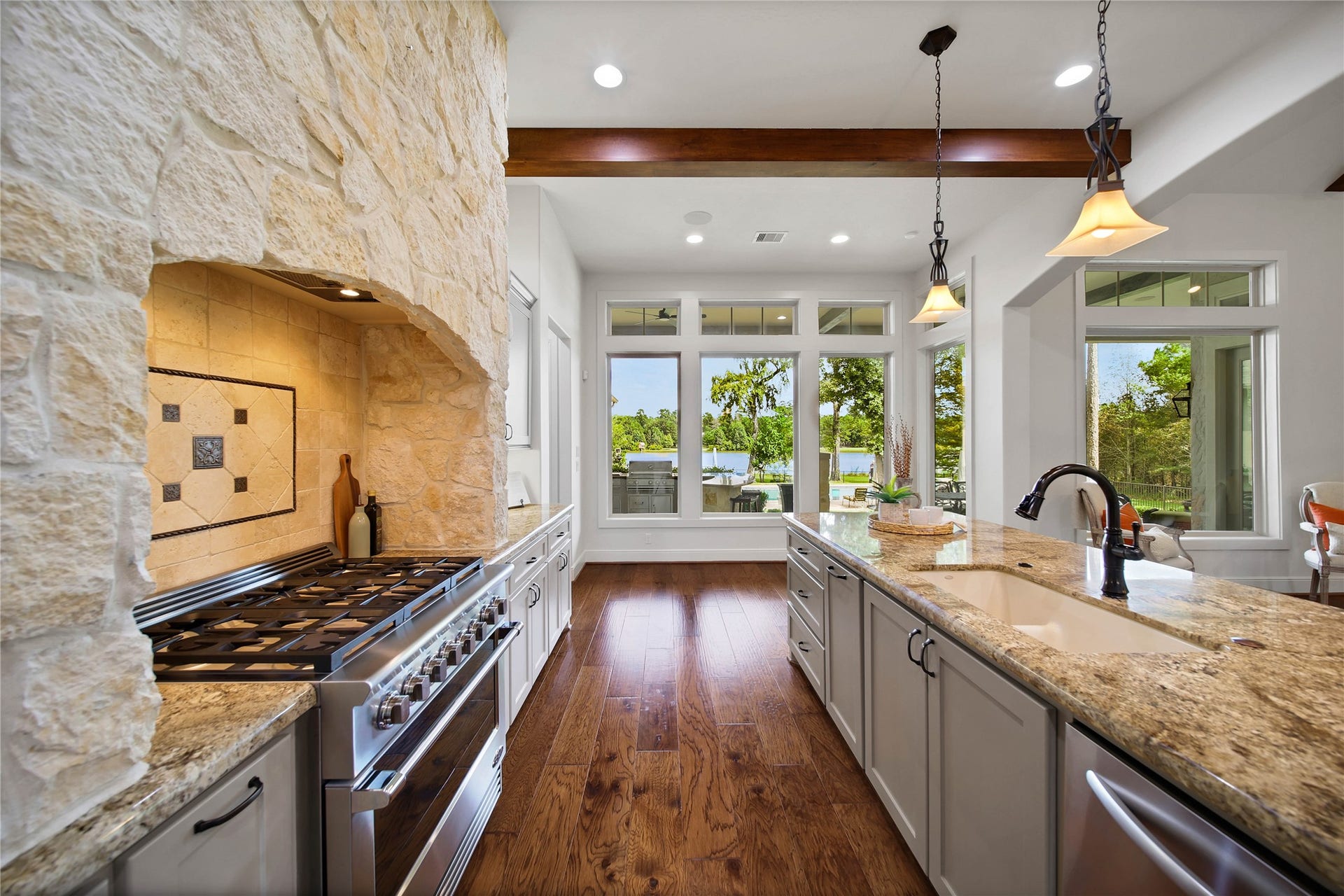 Prepare dinner with greenery beyond the windows and a six-burner gas range at hand. Stone detailing brings character to the cooking area, while the island adds a broad surface for preparation.