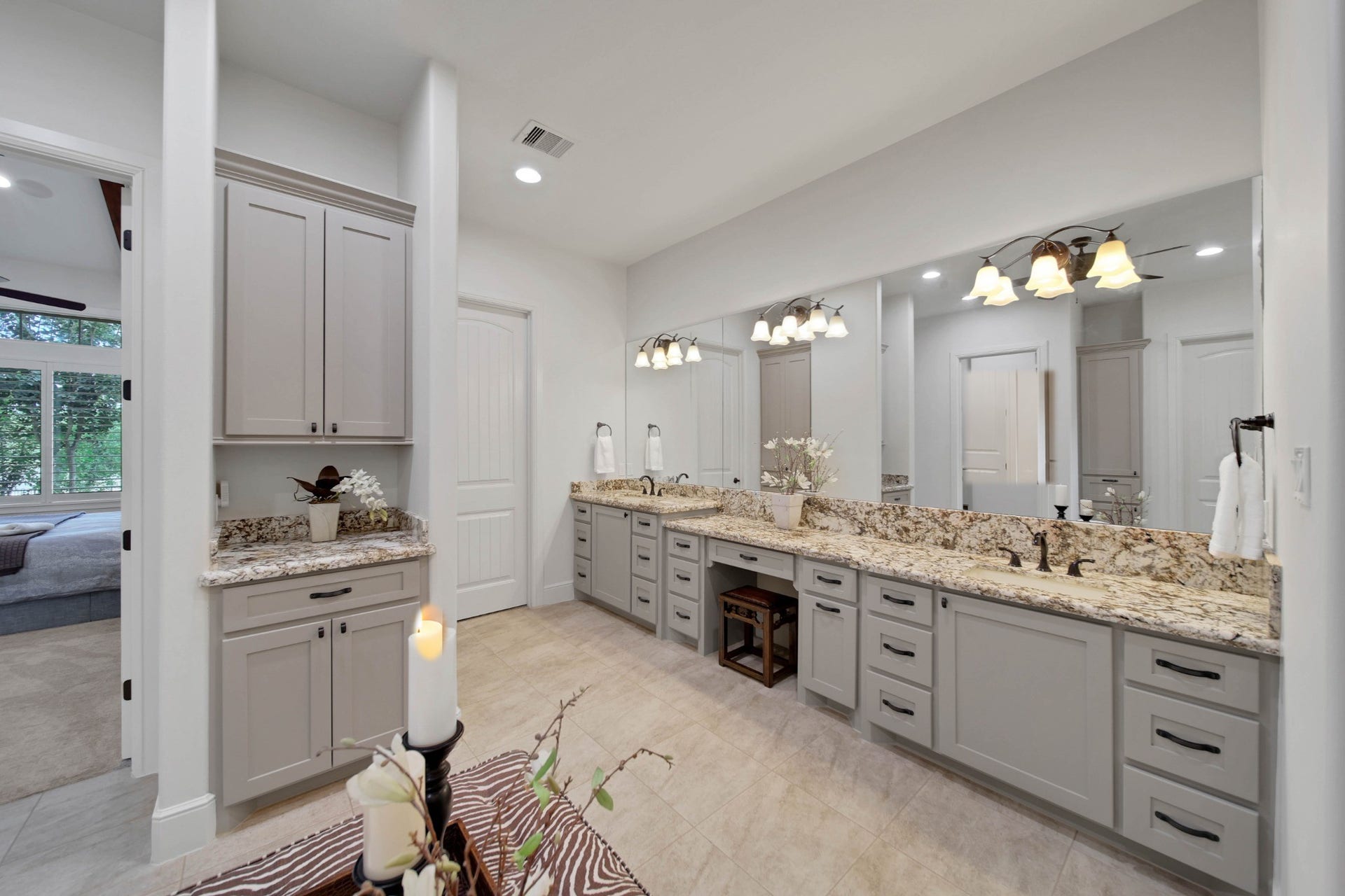 A generous double vanity brings ease to the morning routine. Drawers, cabinetry and broad mirrors keep daily essentials organized within a light, open setting.