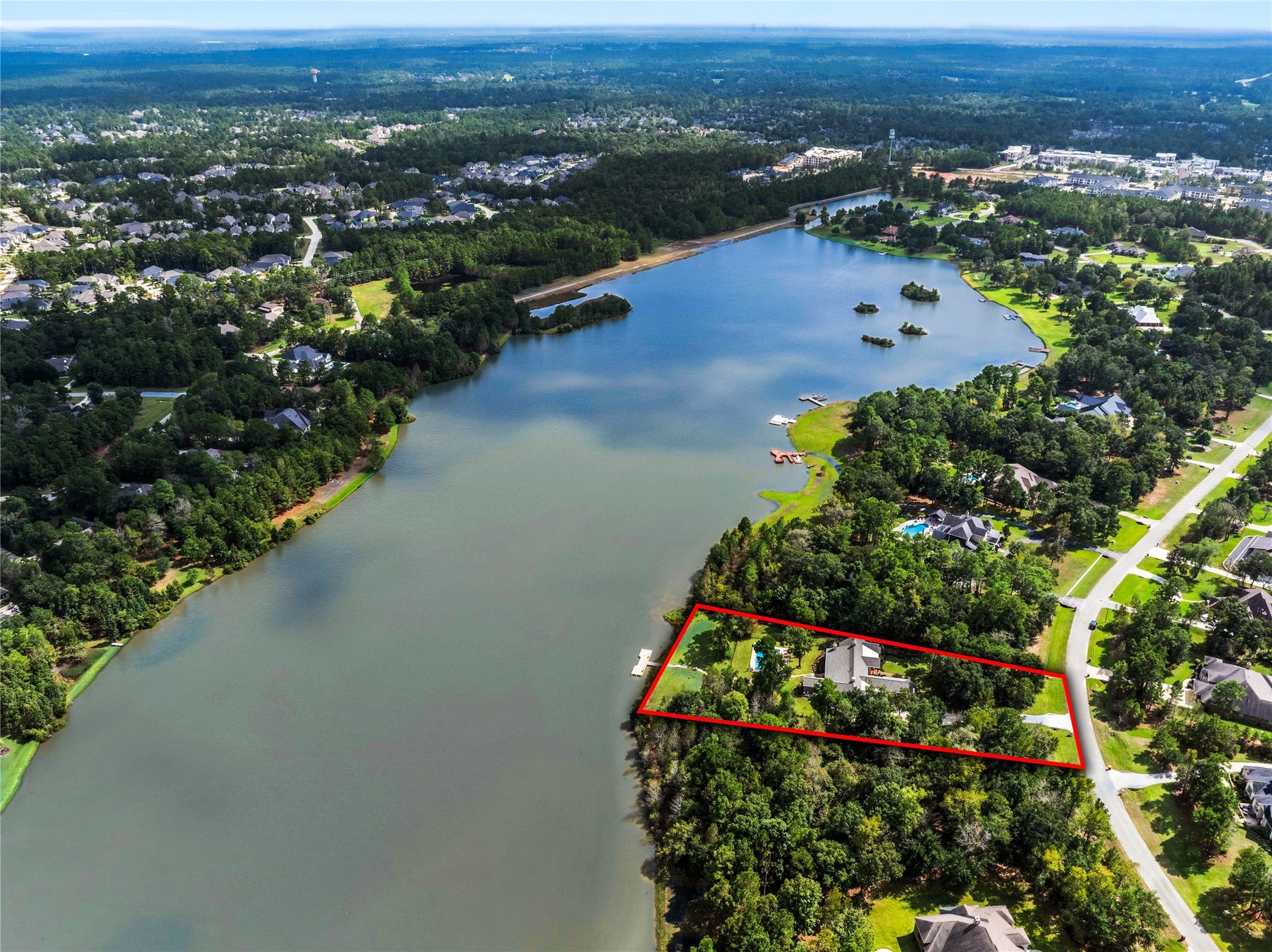 Step back and see how the property sits along the lake. The outlined home parcel brings together a landscaped yard, pool and waterfront setting. Boundary lines are approximate.
