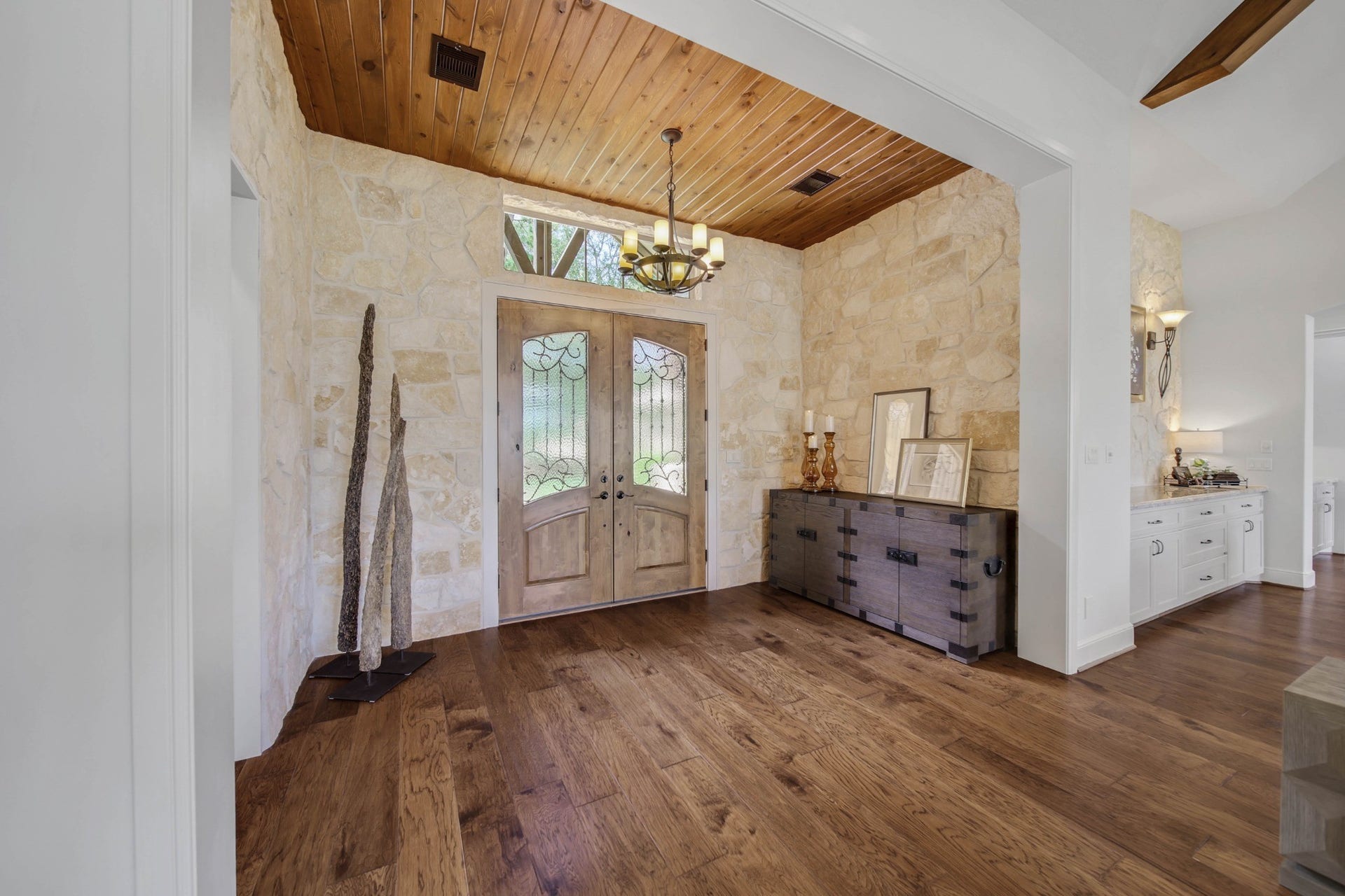 Pause at the entrance and take in the wood ceiling, substantial doors and stone accents. The foyer introduces the home's character before the main living areas unfold.