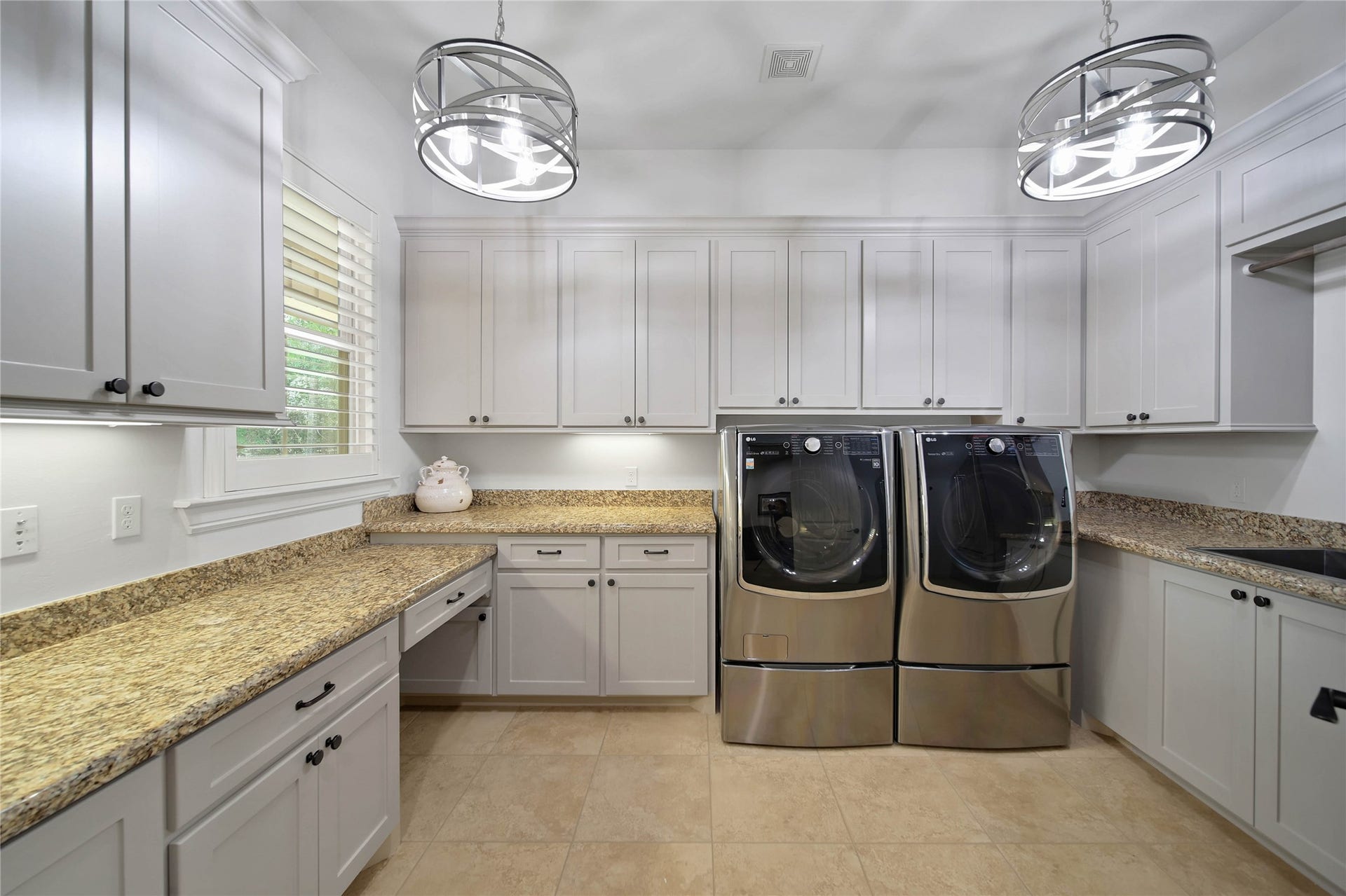 Even your everyday routines are brought to life by the beauty of this home. Counters, cabinetry and a utility sink make this laundry room useful for sorting, folding and keeping household tasks organized.