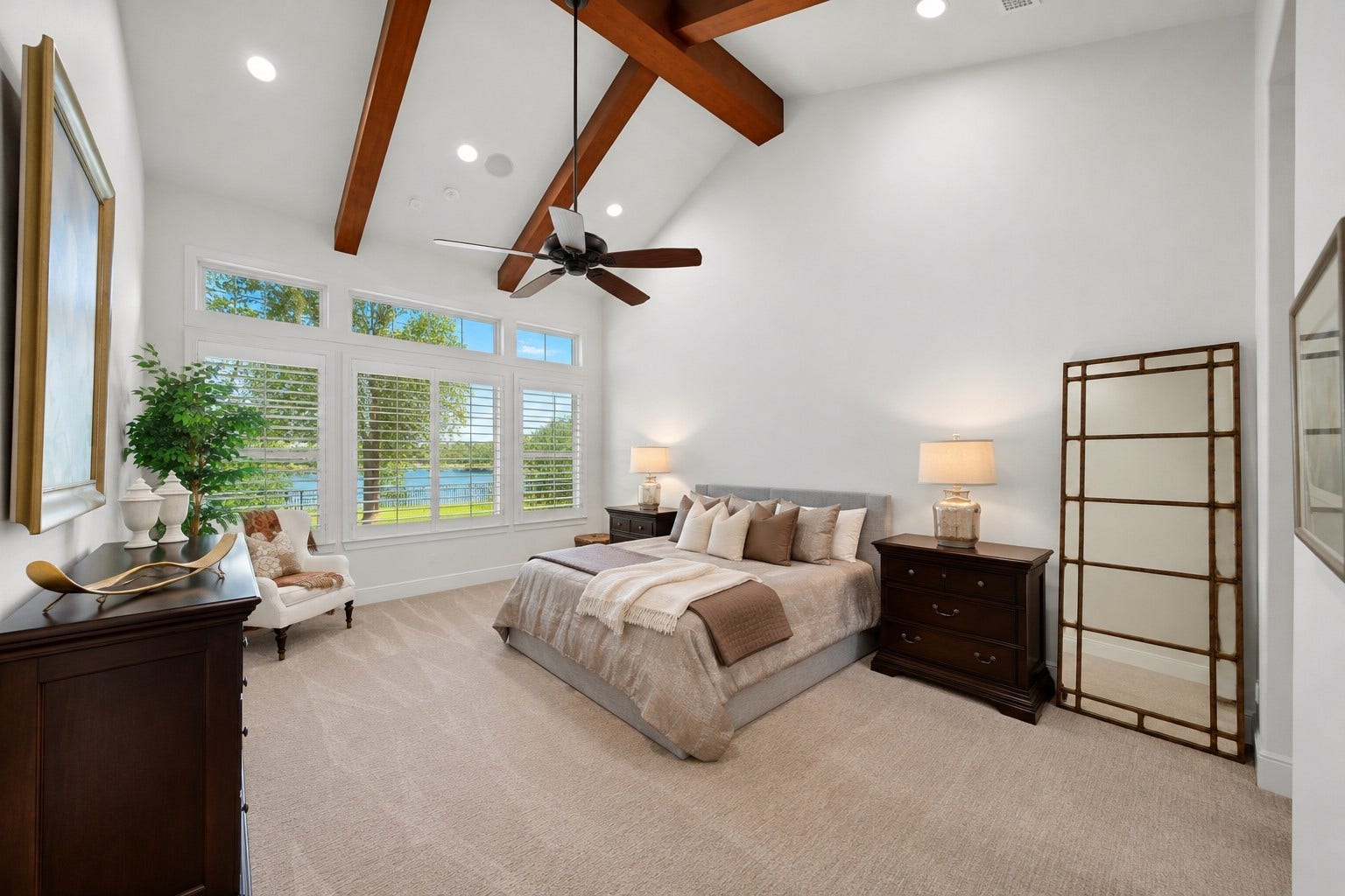The owner's retreat features vaulted beam ceilings and a wall of windows overlooking the lake.