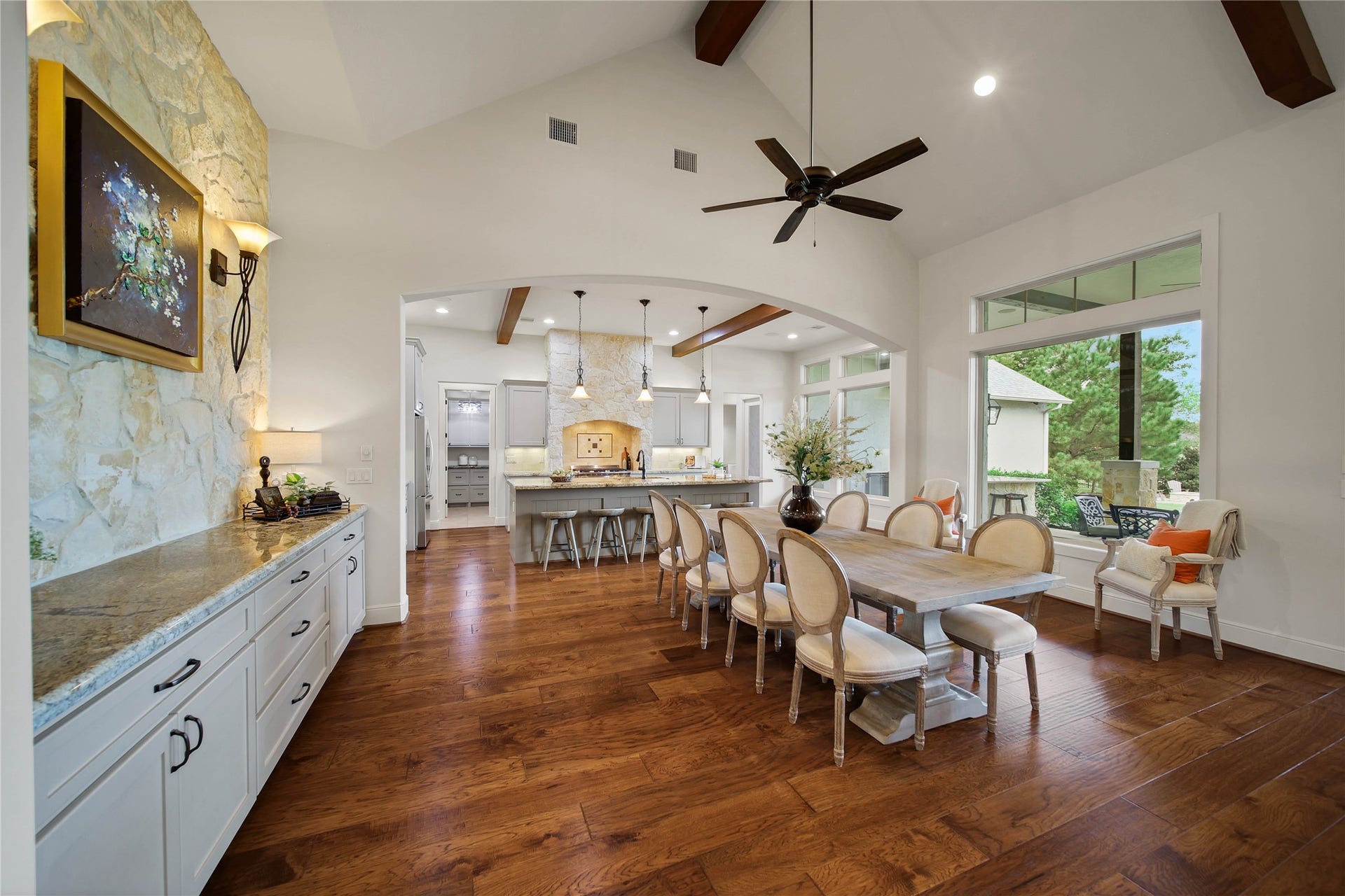 The table has a setting worthy of the occasion. Nearby cabinetry provides a place for serving pieces, while the open layout welcomes everything from everyday meals to a full evening of entertaining.