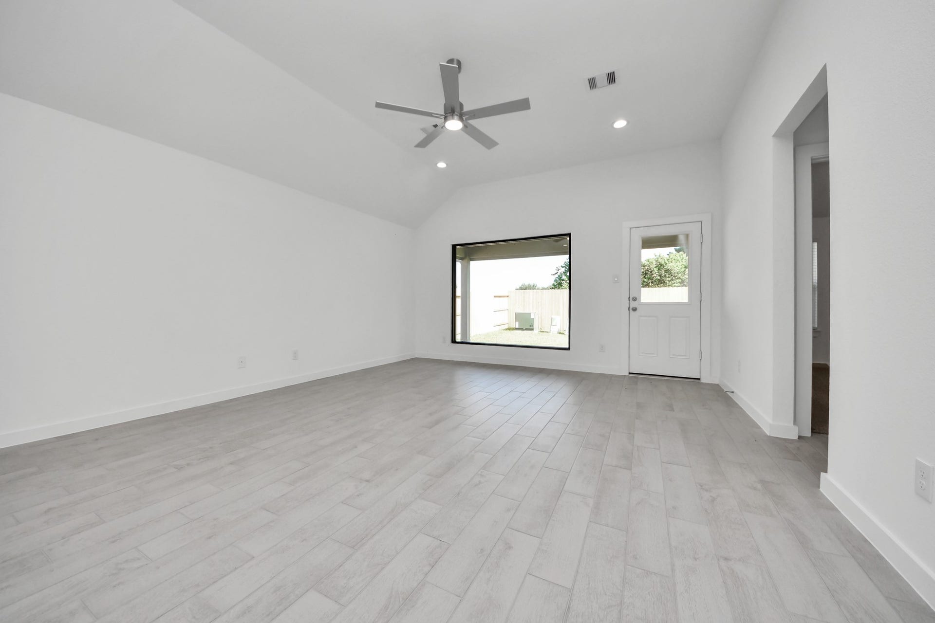11015 Hosta Stream Drive, Houston, TX 77044 Family room flooded with natural light through the expansive windows. The premium tile flooring adds a touch of luxury to the space, creating the perfect setting for relaxing moments and cherished gatherings with loved ones. Sample photo of completed home with similar floor plan. Actual colors and selections may vary.