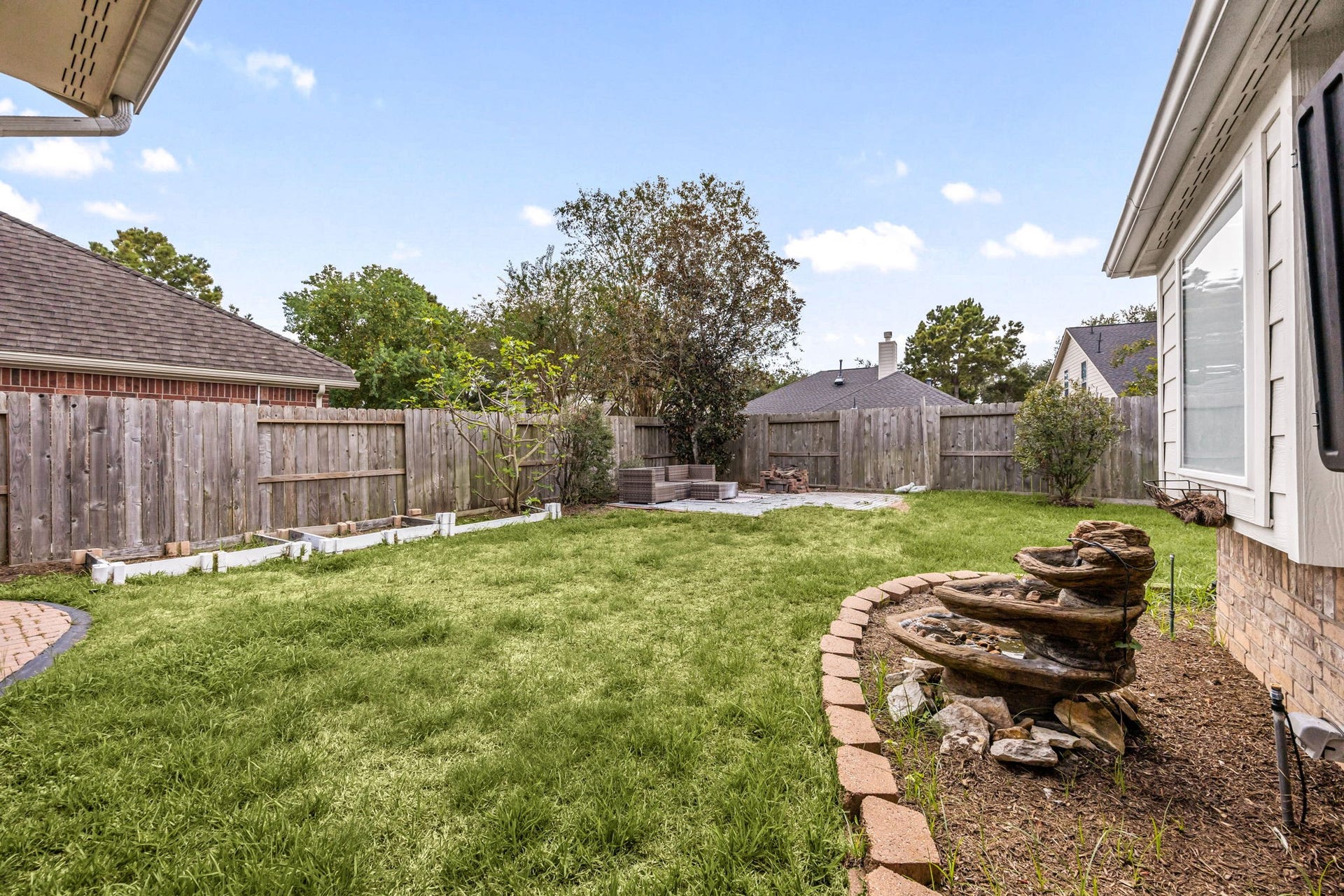 4730 Camden Brook Lane, Katy, TX 77494 Spacious fenced backyard featuring a large grassy area, mature landscaping, and plenty of room for outdoor activities.