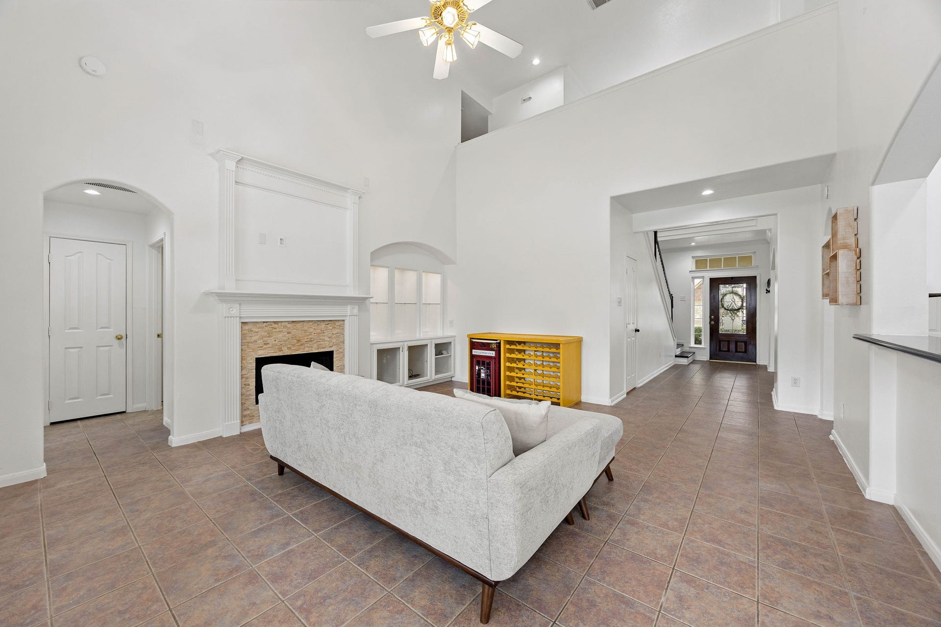 4730 Camden Brook Lane, Katy, TX 77494 Spacious living room featuring a fireplace, ceiling fan, neutral finishes, and an open connection to the kitchen.