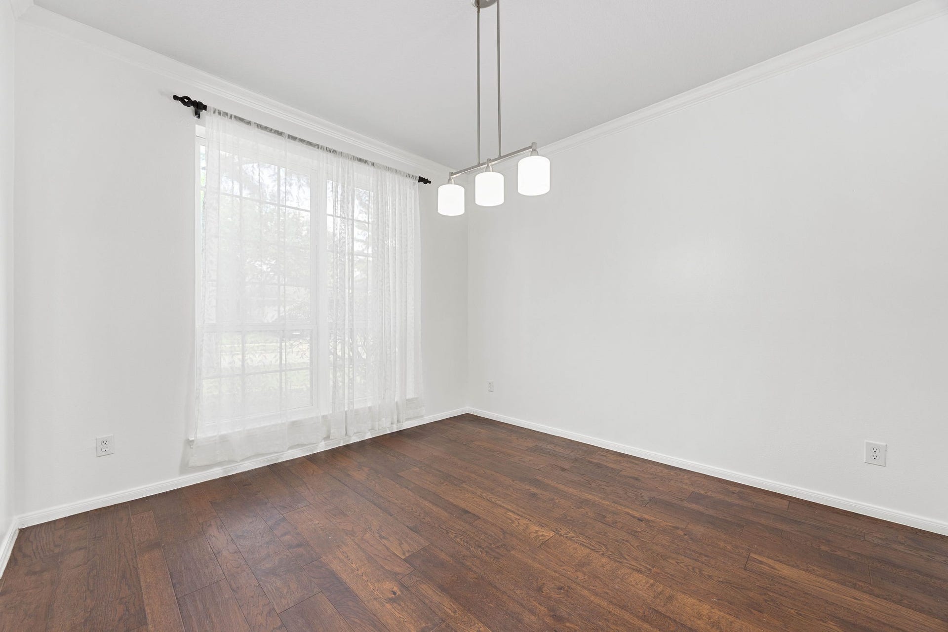 4730 Camden Brook Lane, Katy, TX 77494 Formal dining area featuring rich wood flooring, contemporary lighting, and abundant natural light from large windows.