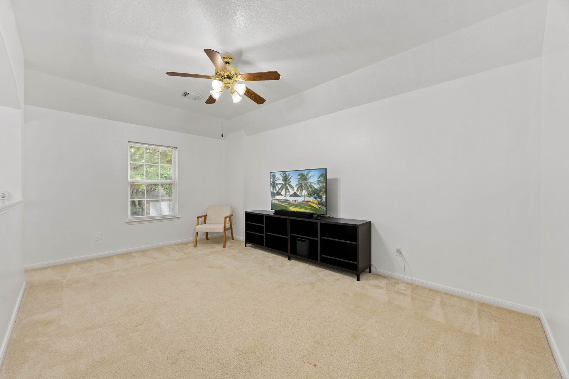 4730 Camden Brook Lane, Katy, TX 77494 Spacious upstairs game room featuring a ceiling fan, neutral finishes, and flexible space for entertainment or relaxation.