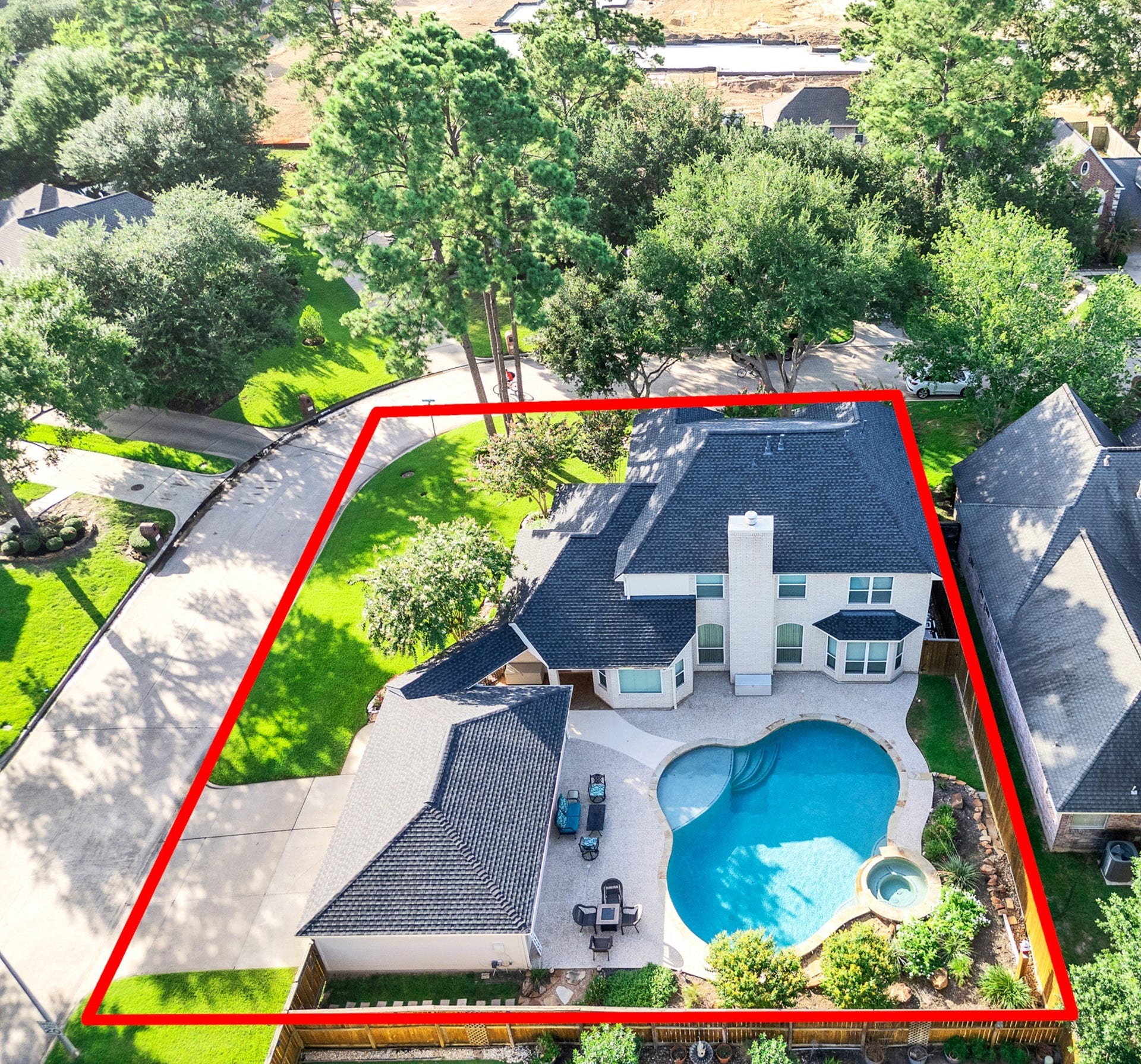 3415 Cypressdale Court, Spring, TX 77388 Aerial view of the beautiful backyard featuring a large pool and heated spa, surrounded by lush greenery and mature trees. 3 car garage w/ double driveway is featured to the left.