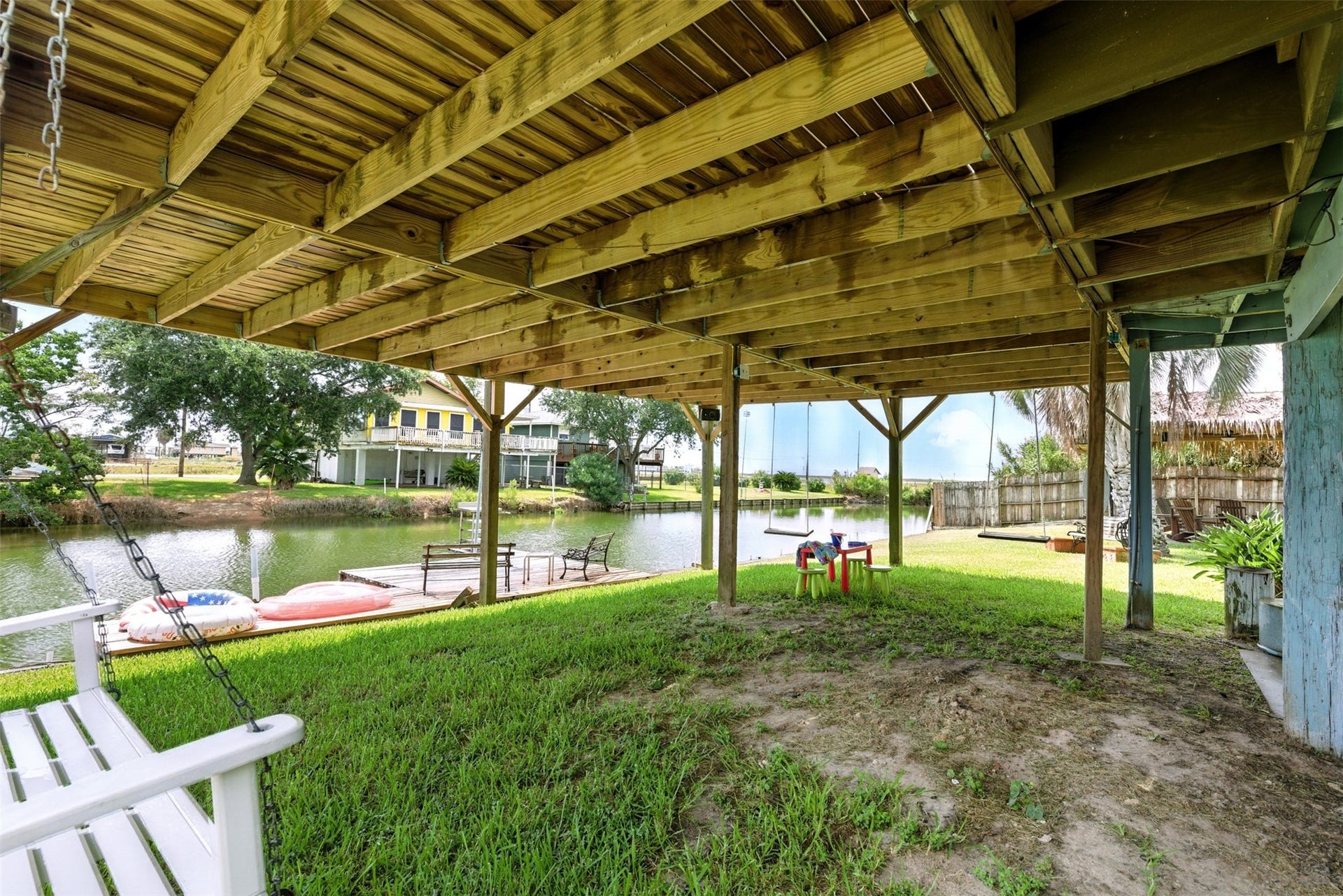 7215 Beau Rue Street, Hitchcock, TX 77563 green space under the home with swings and view of the dock