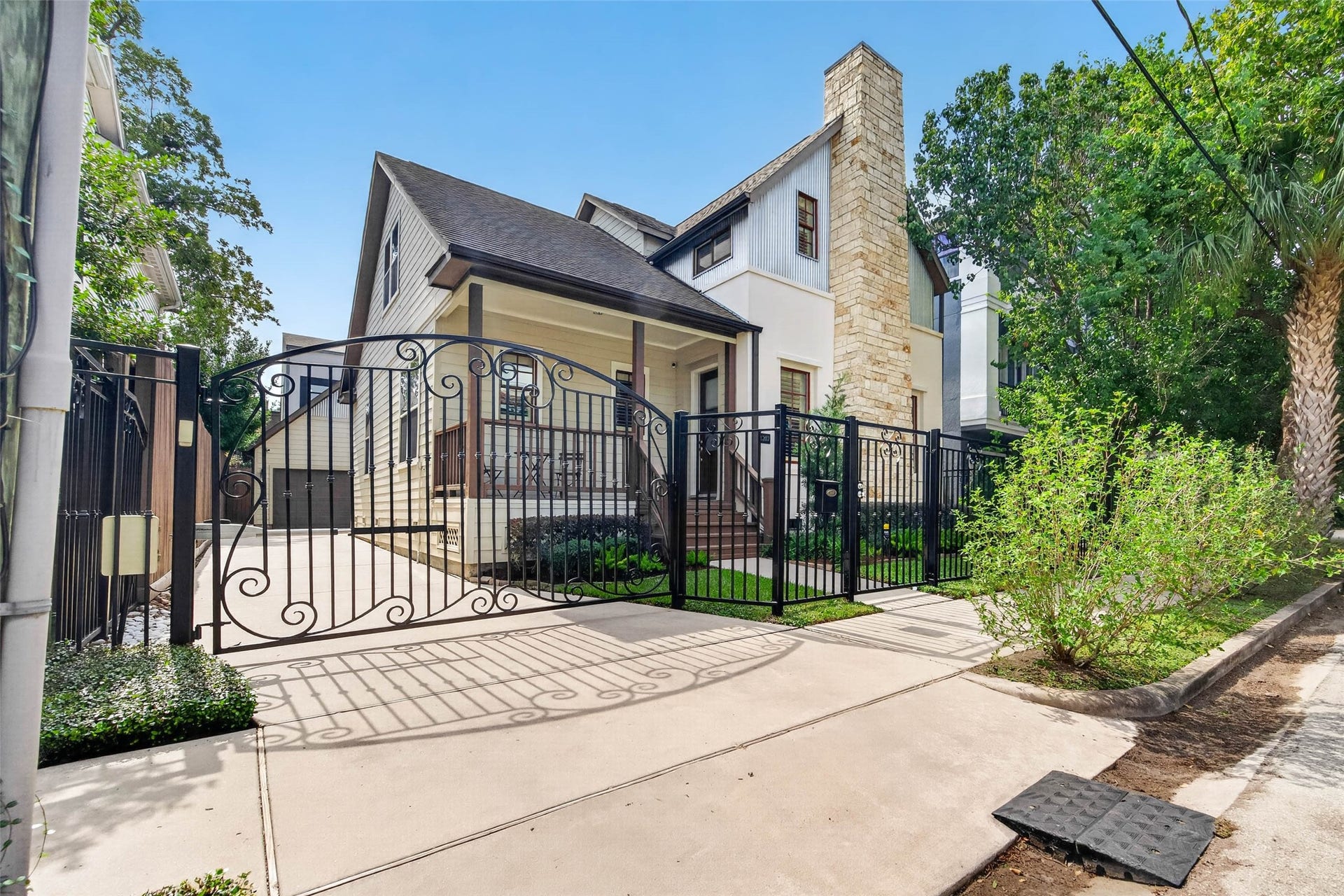 1207 Welch Street, Houston, TX 77006 Charming curb appeal with thoughtful details throughout. The classic wrought-iron fence, gated driveway, and separate pedestrian gate offer both character and privacy, while the neatly maintained front garden beds add a touch of greenery and warmth.