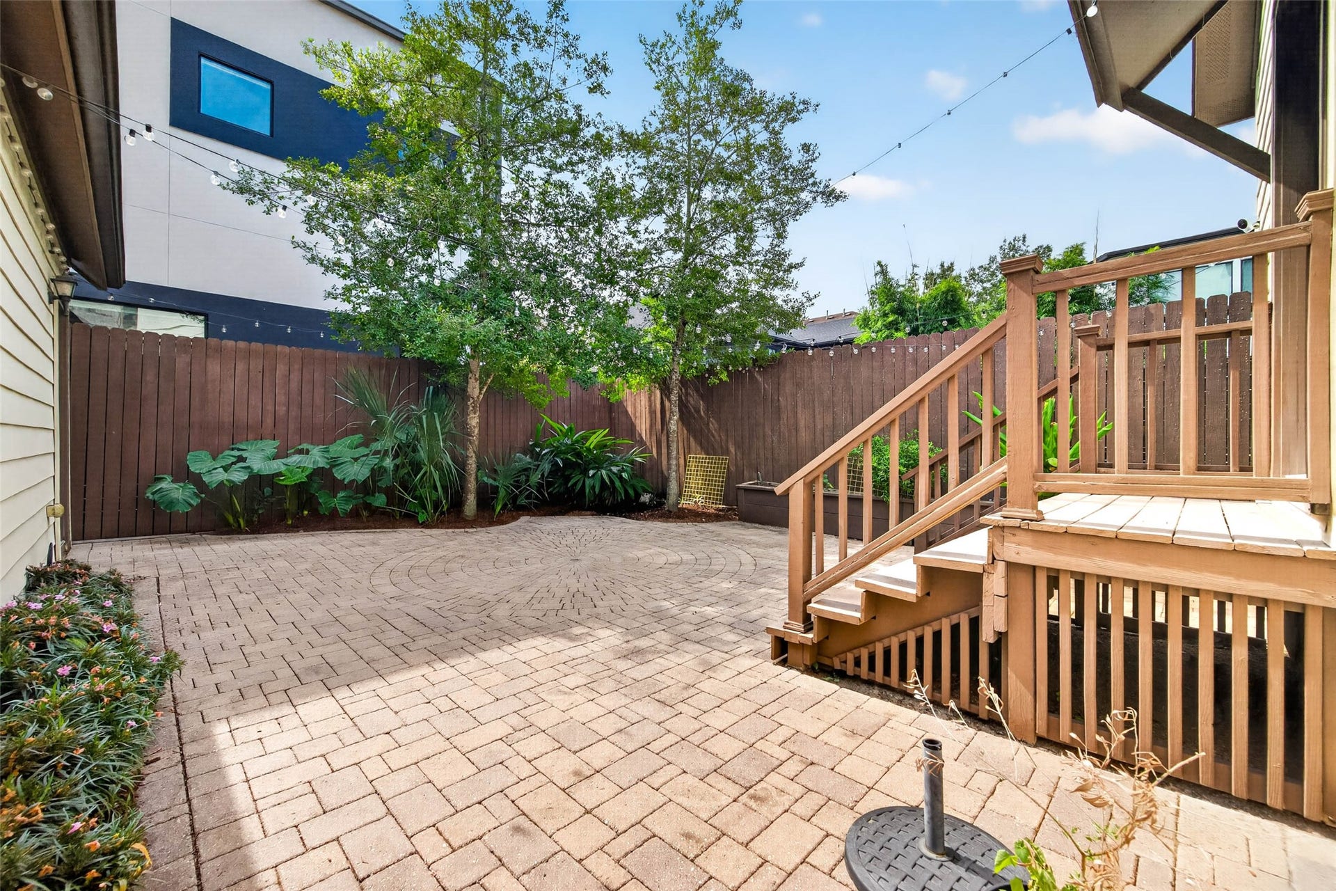 1207 Welch Street, Houston, TX 77006 Step outside to a paved backyard bordered by lush greenery, creating a charming and private outdoor space to relax or entertain.
