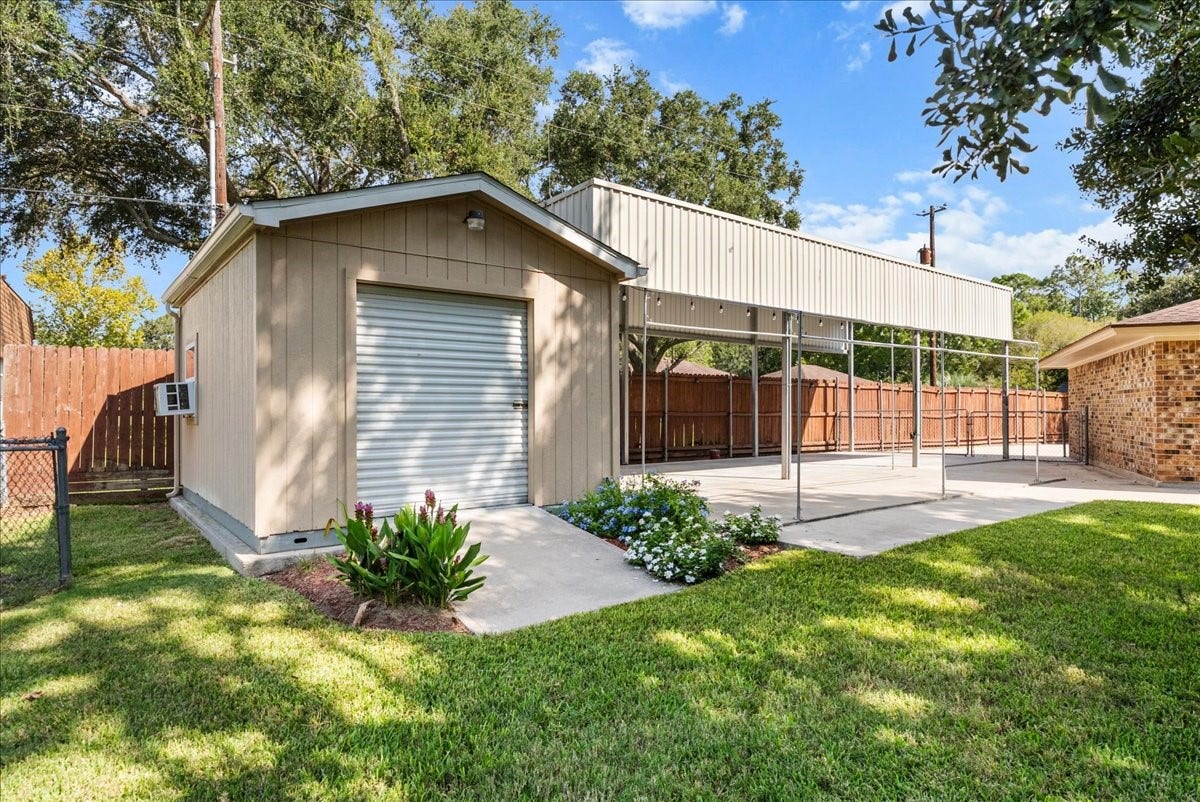 802 Riverside Drive, Alvin, TX 77511 Spacious backyard with a versatile shed and covered carport, ideal for storage or outdoor projects, and a covered parking large enough for an RV.
