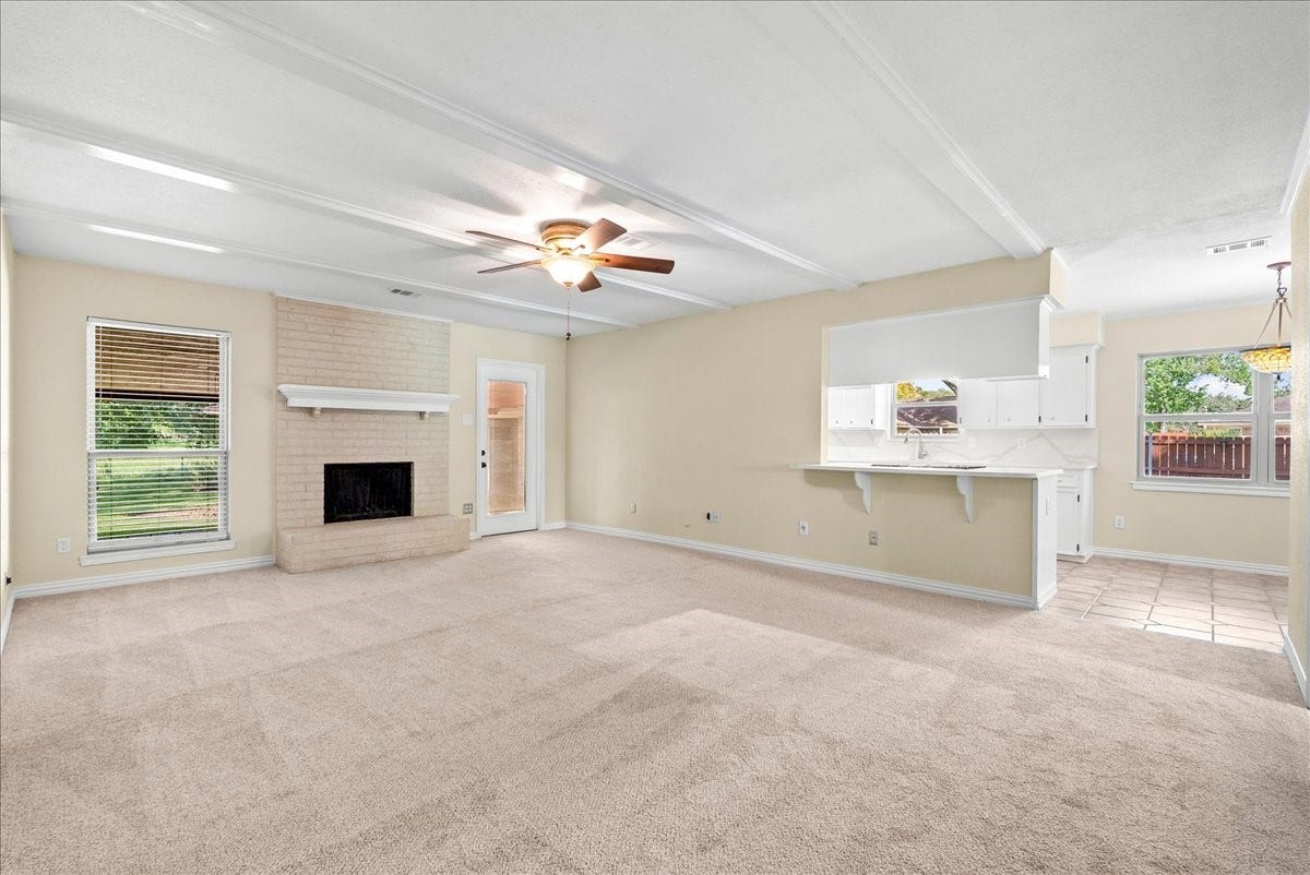 802 Riverside Drive, Alvin, TX 77511 Spacious living area with a cozy brick fireplace, and seamlessly connecting to a bright kitchen, breakfast room and foyer.