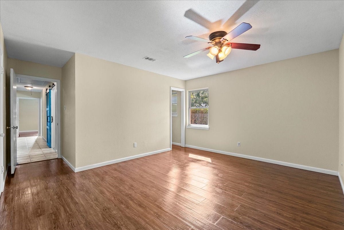 802 Riverside Drive, Alvin, TX 77511 Spacious primary bedroom featuring durable laminate flooring and a private en-suite bathroom for added convenience.