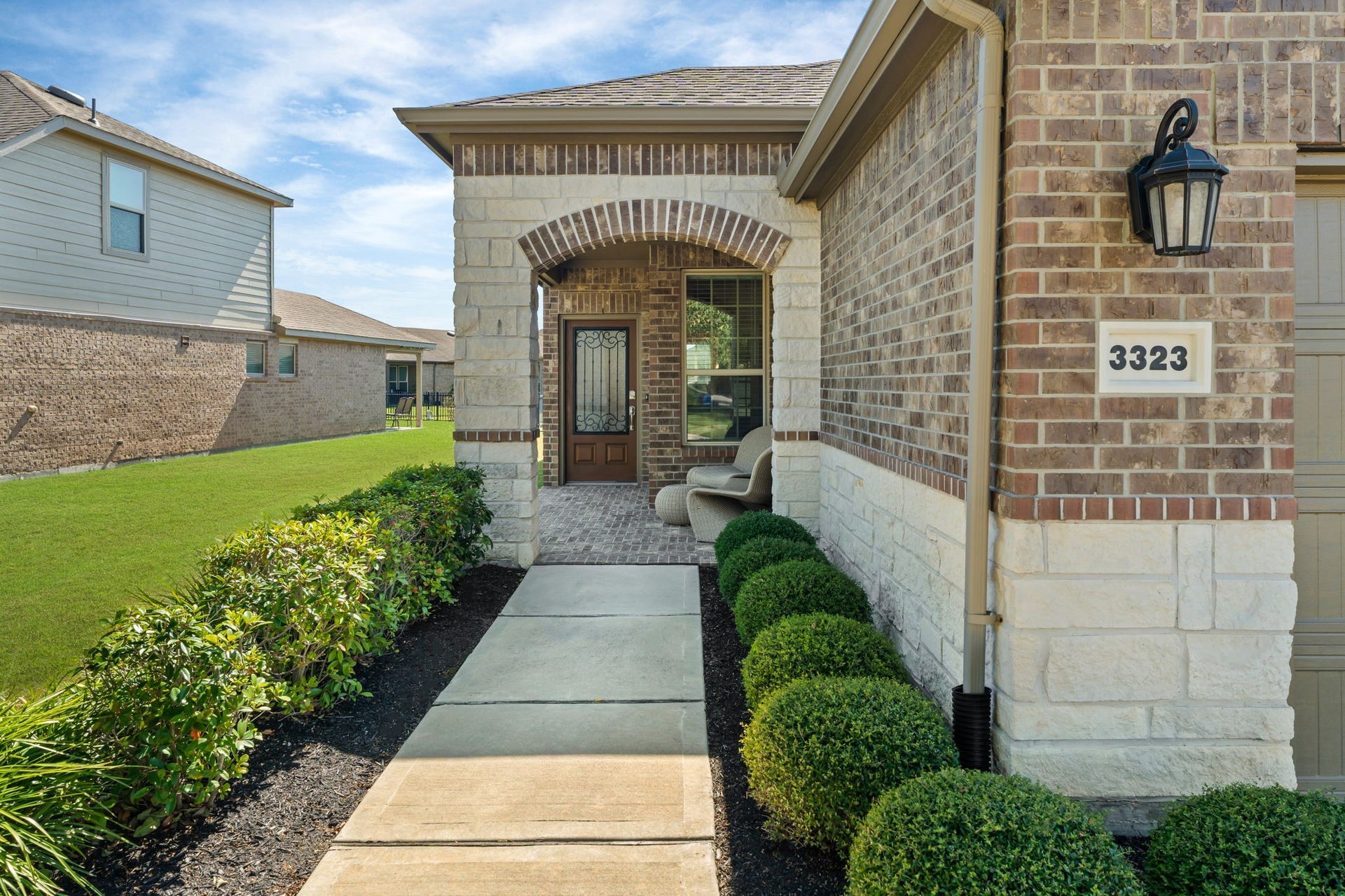 Beautiful arched entry creates an inviting first impression! Welcome home! Charming front porch greets guests in style.