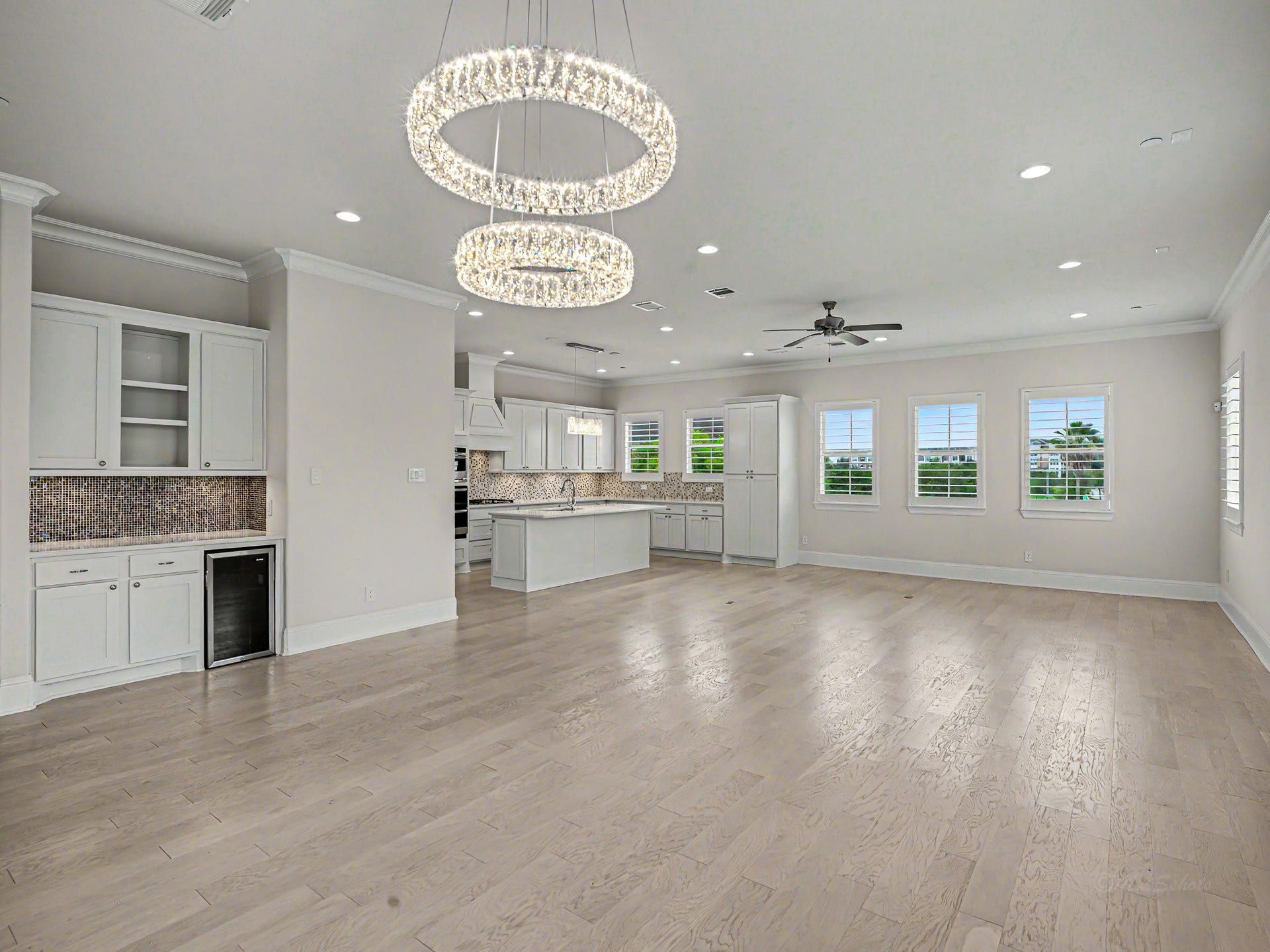 Looking back towards the center island kitchen with Quartz countertops & plenty of room for bar stools. Even more windows across the back wall & kitchen, too.