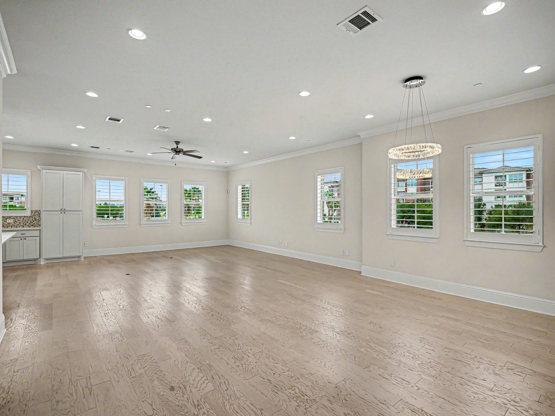 How breath-taking is this! This open flowing floor plan lets in tons of natural light. All windows have Plantation Shutters. High-end light fixture in the dining area.