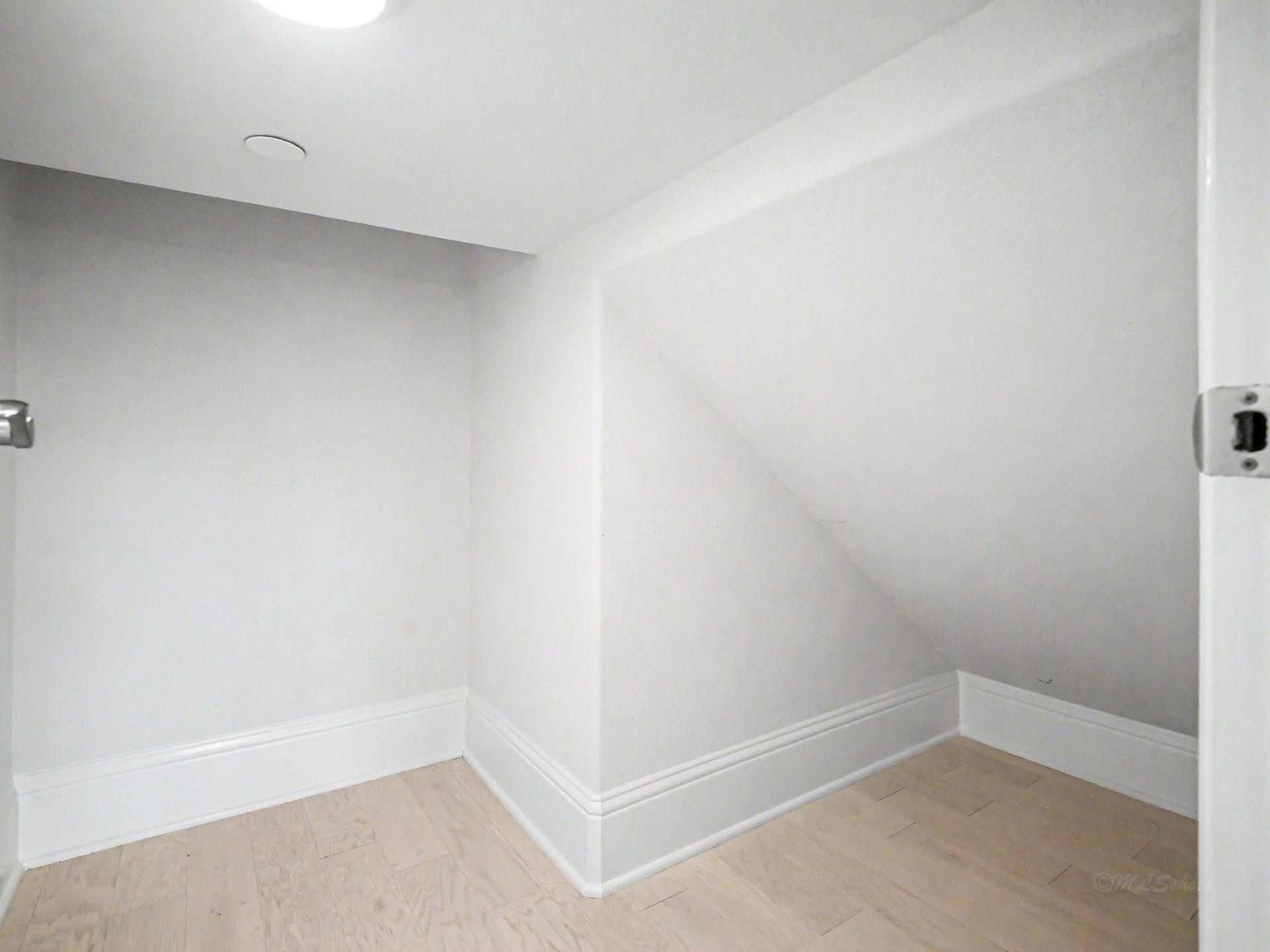Built-in storage room under the staircase, complete with matching flooring & baseboards!
