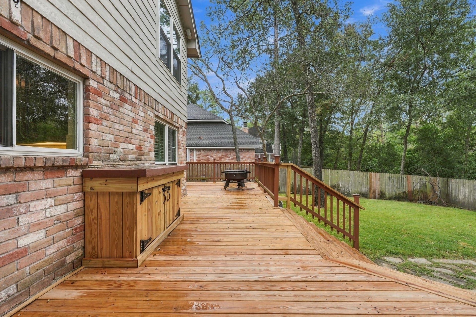 8 Diamond Oak Court, The Woodlands, TX 77381 Another angle of the spacious deck, showcasing the open outdoor space and surrounding mature trees.