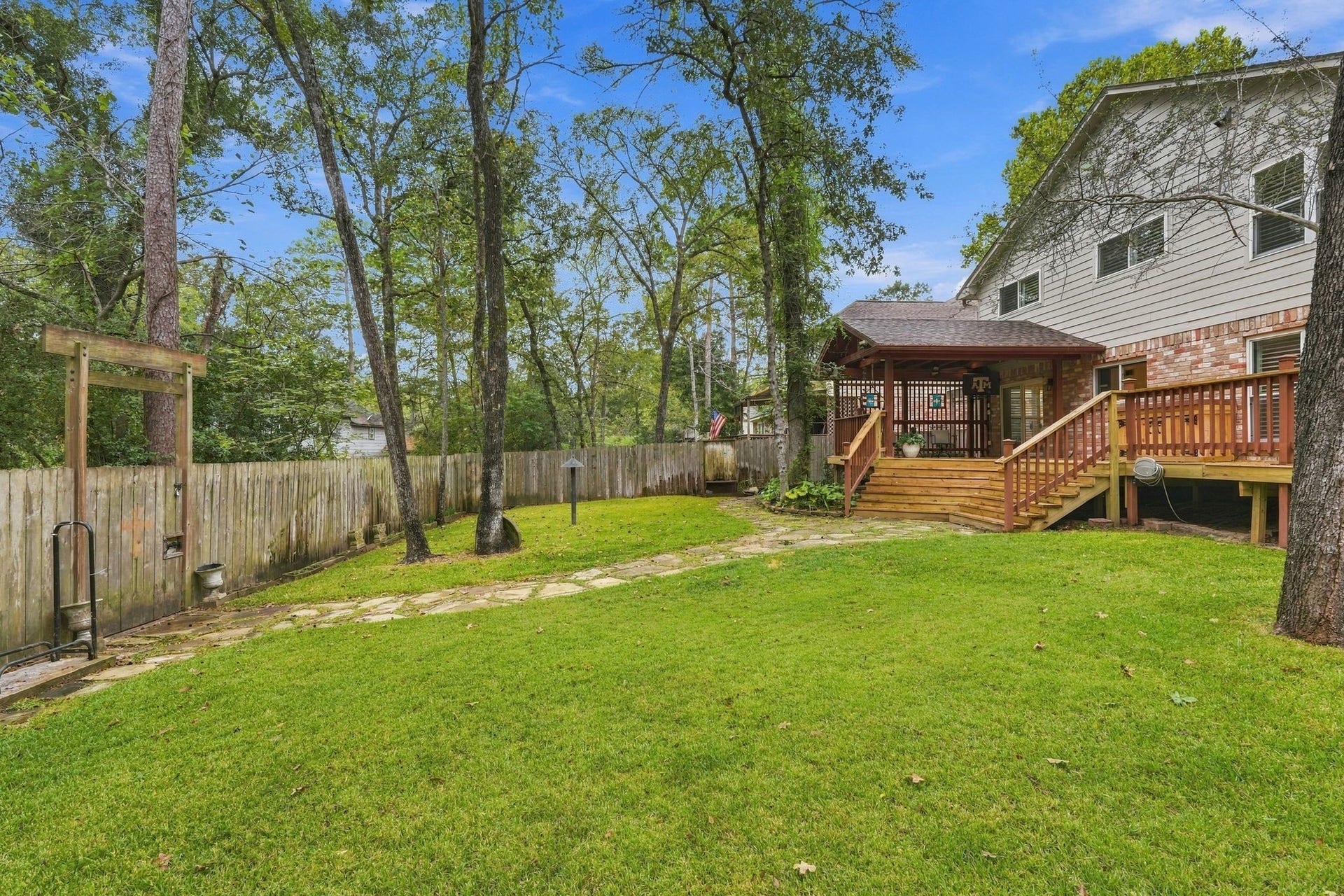 8 Diamond Oak Court, The Woodlands, TX 77381 Another view of the expansive backyard, offering plenty of room to relax, play, or entertain. There is a pathway that runs behind the fence on the left- perfect to open your gate and go for a walk or run on the Woodlands trails!