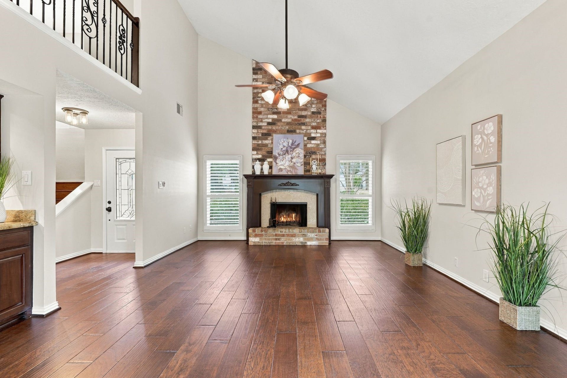 8 Diamond Oak Court, The Woodlands, TX 77381 Living room featuring a beautiful wood burning fireplace, soaring ceilings, and an abundance of natural light. This home has Plantation Shutters on all windows.