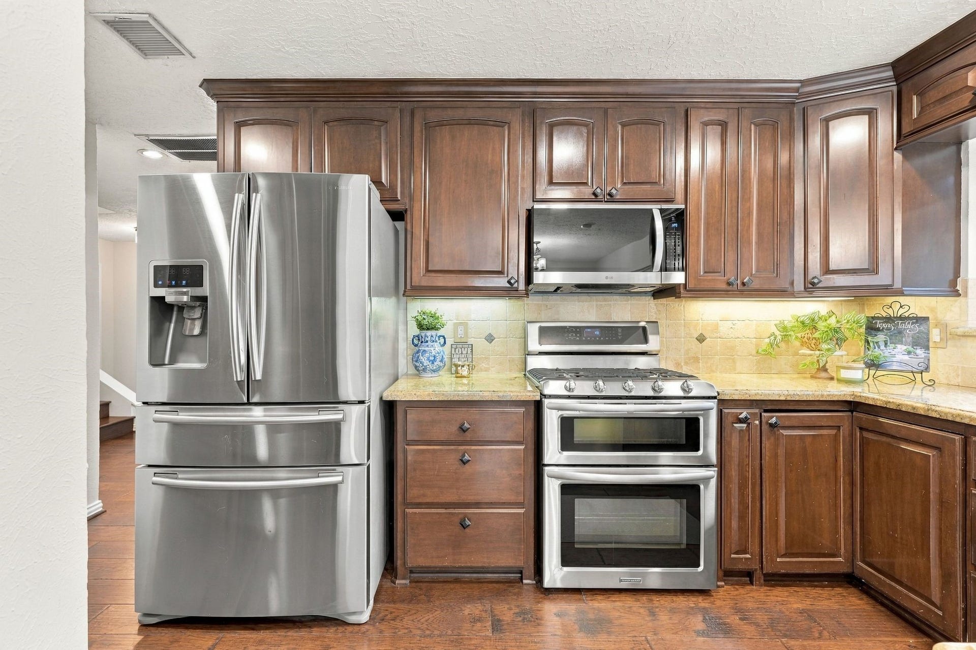 8 Diamond Oak Court, The Woodlands, TX 77381 Kitchen featuring rich wood cabinetry, generous granite counter space, and a functional layout. Refrigerator conveys with the home.