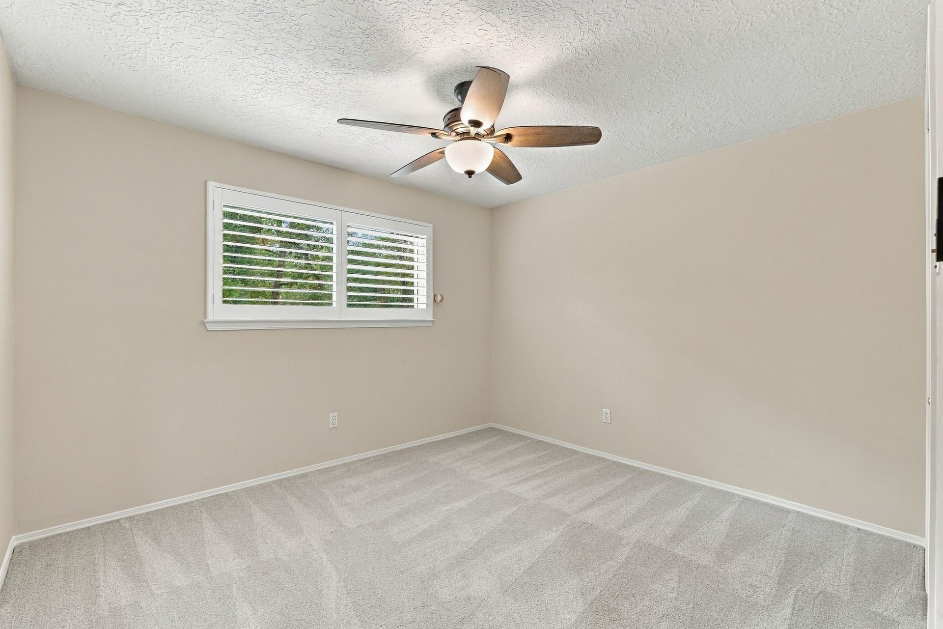 8 Diamond Oak Court, The Woodlands, TX 77381 Secondary Bedroom with a ceiling fan and windows overlooking the outdoors and built-ins in the closet.