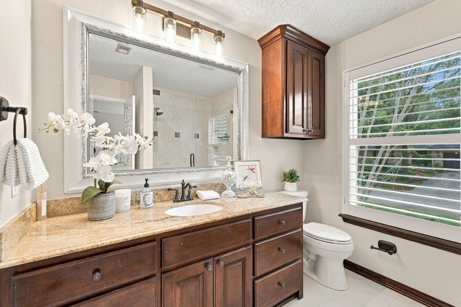 8 Diamond Oak Court, The Woodlands, TX 77381 Primary bathroom with generous granite counter space, and large windows bringing in natural light.