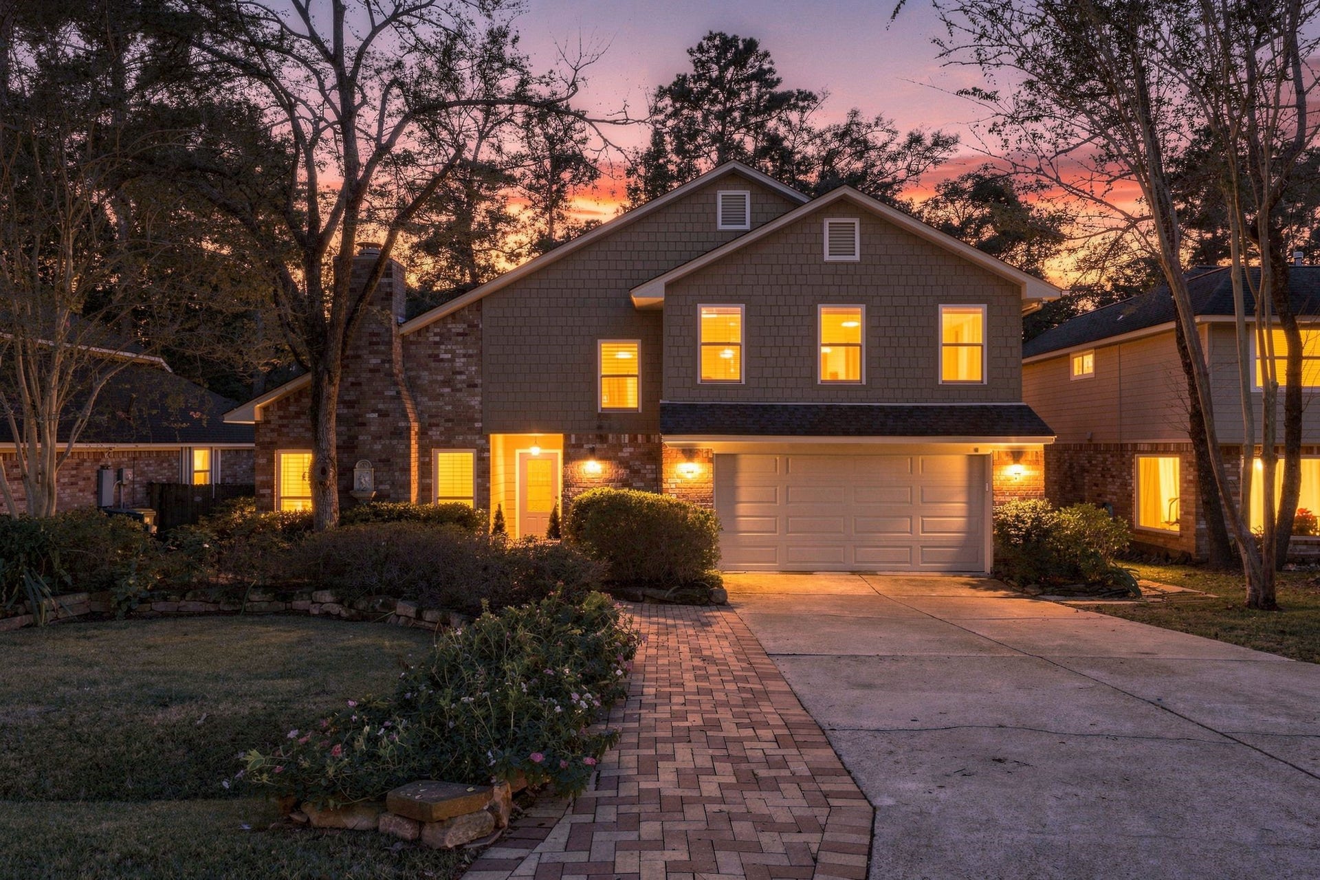 8 Diamond Oak Court, The Woodlands, TX 77381 Stunning evening view of the home, showcasing its beautiful exterior and warm, inviting lighting. This could be yours just in time for the Holidays!