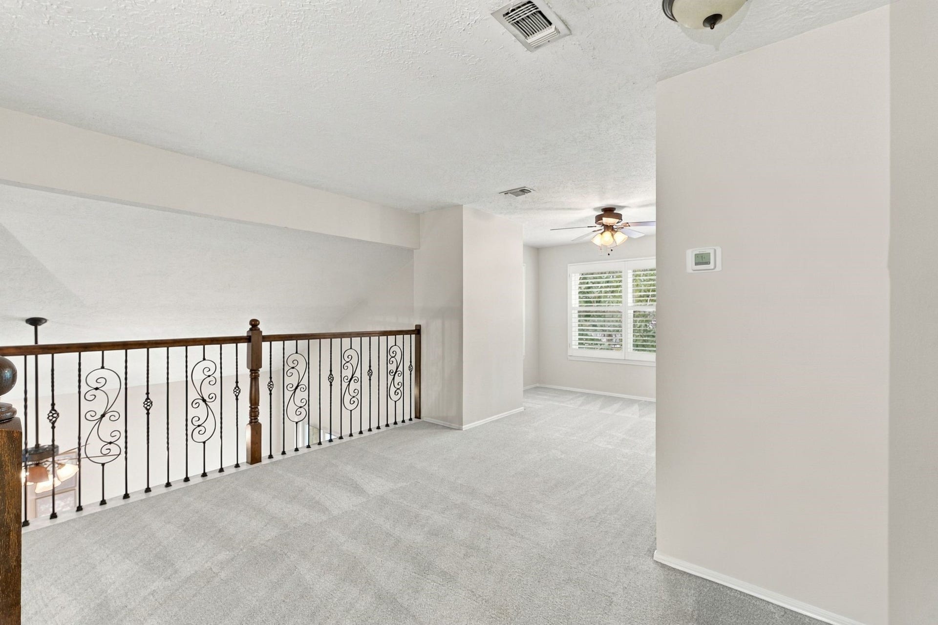 8 Diamond Oak Court, The Woodlands, TX 77381 Upstairs loft with a ceiling fan and open railing overlooking the lower level.
