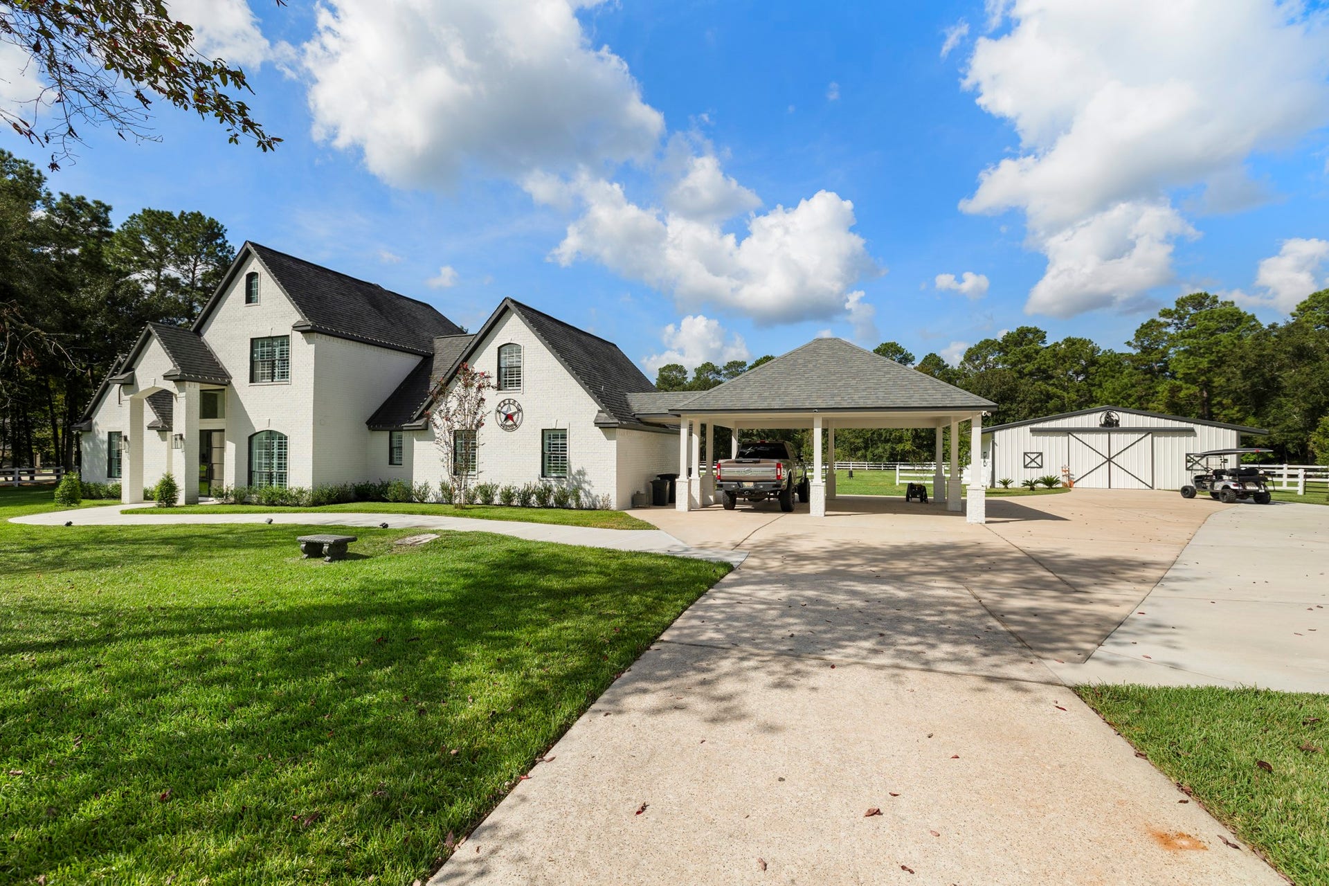 31219 Edgewater Drive, Magnolia, TX 77354 A wider view takes in the home, landscaped grounds and covered parking.