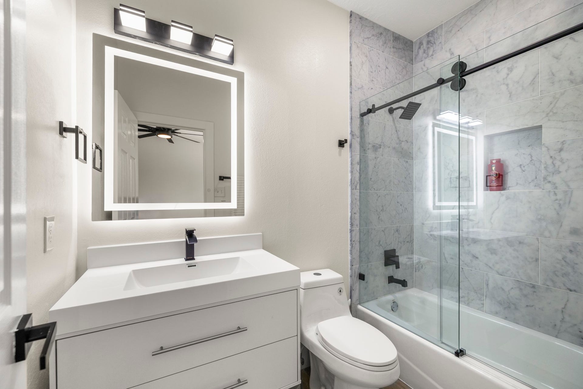 31219 Edgewater Drive, Magnolia, TX 77354 Another secondary bathroom pairs a streamlined vanity with a glass-enclosed tub and shower finished in marble tile.