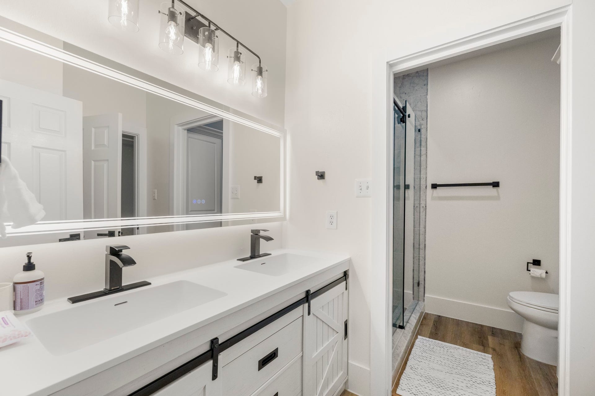 31219 Edgewater Drive, Magnolia, TX 77354 A double-sink vanity and glass-enclosed shower complete the adjoining bathroom.