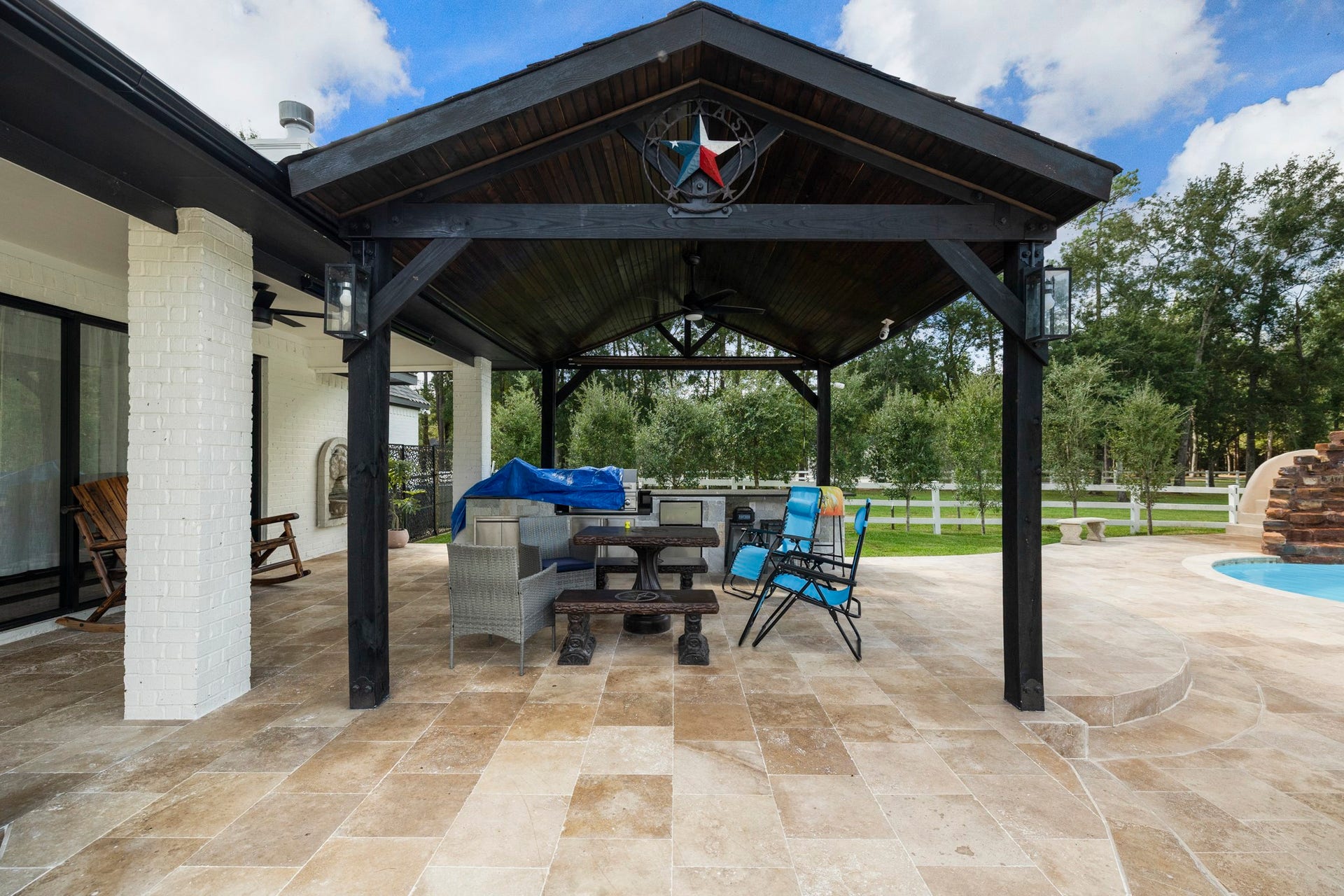 31219 Edgewater Drive, Magnolia, TX 77354 Step outside to the newly added covered patio overlooking the pool area. space beside the pool.