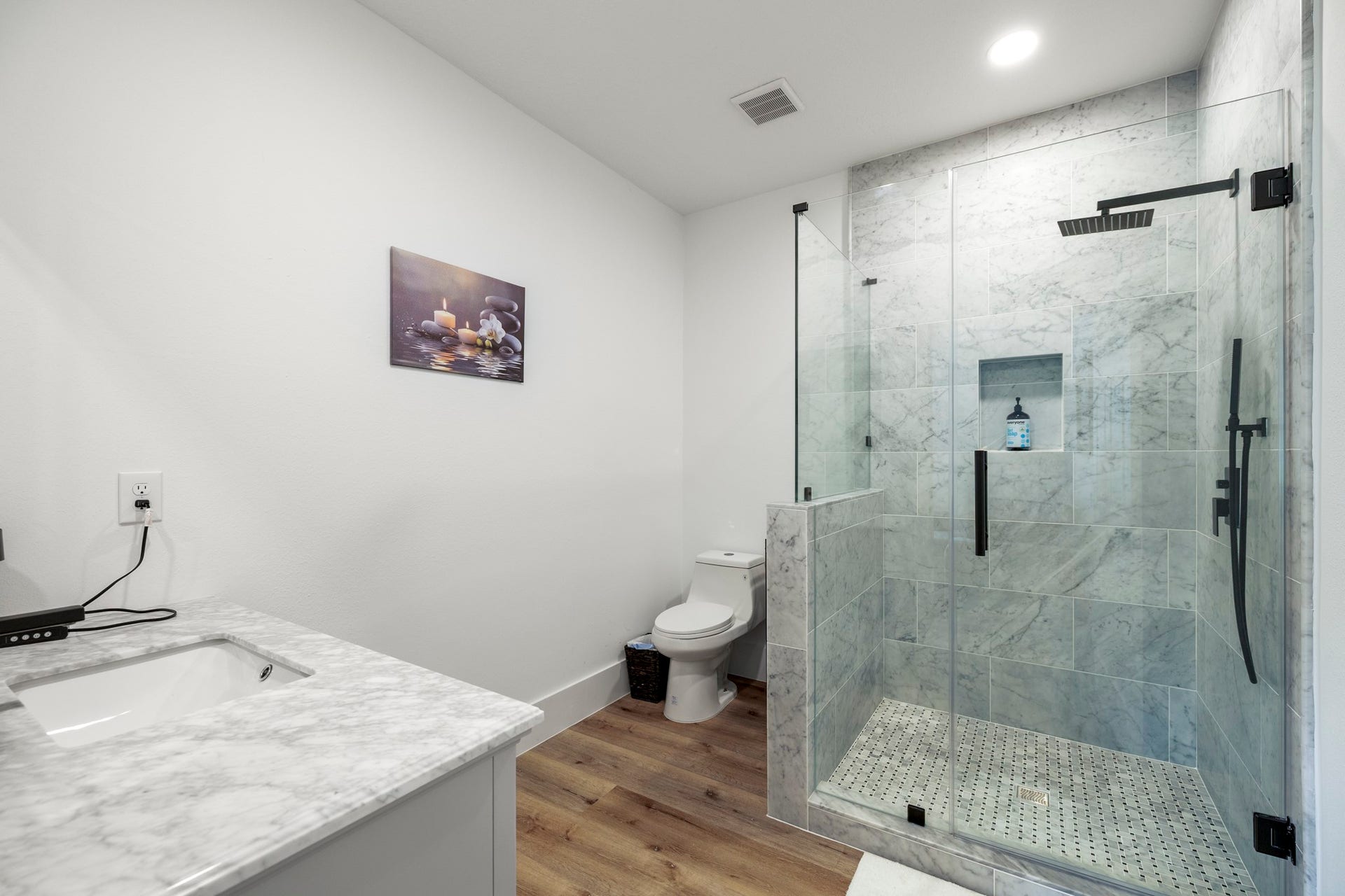 31219 Edgewater Drive, Magnolia, TX 77354 The ensuite bathroom features a glass-enclosed shower with marble tile and dark fixtures.