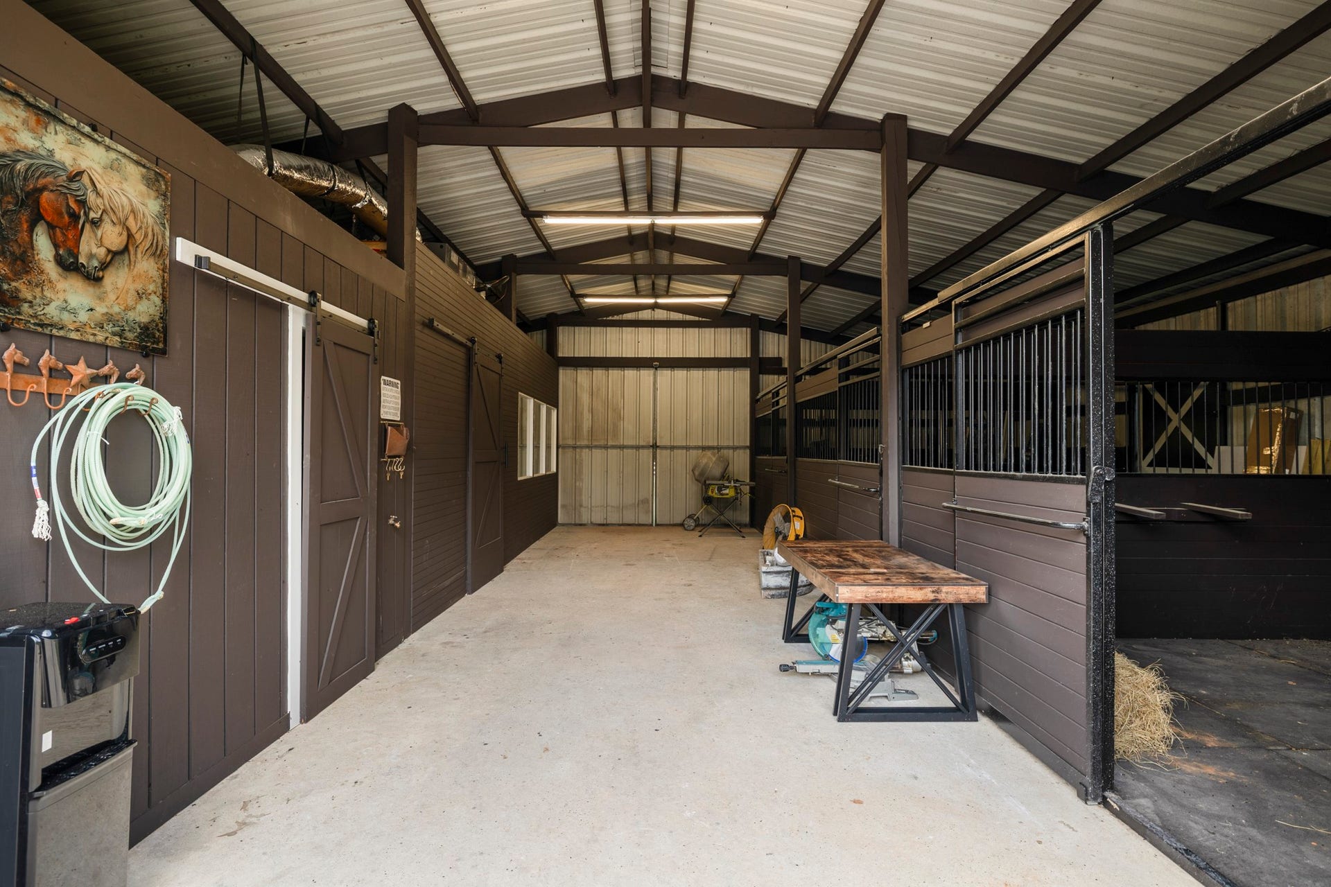 31219 Edgewater Drive, Magnolia, TX 77354 Inside the barn, a covered central aisle provides access to multiple stalls.
