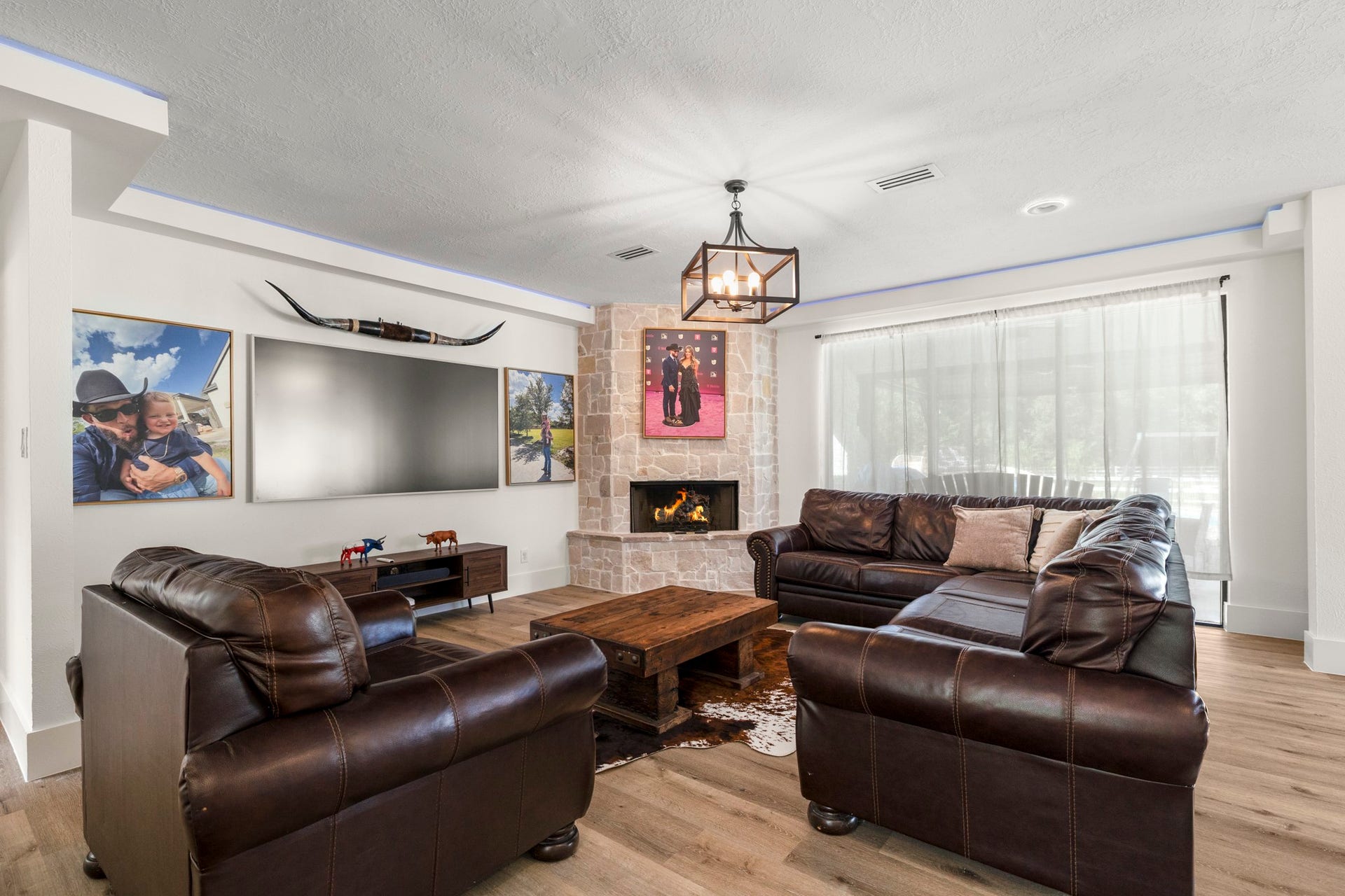 31219 Edgewater Drive, Magnolia, TX 77354 The living room features a fireplace, wood-look flooring and newly installed patio doors that connect the space to the outdoors.