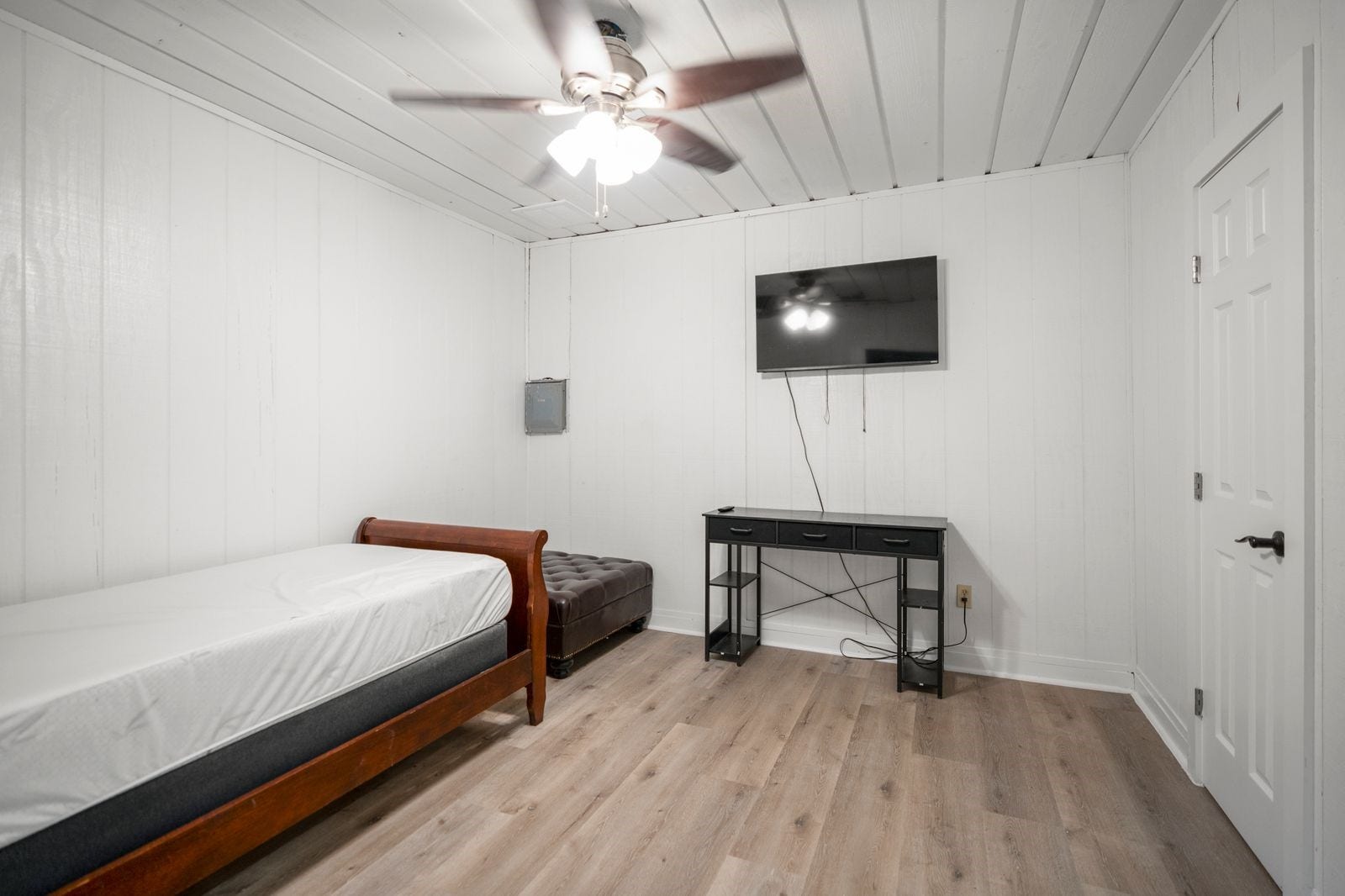 31219 Edgewater Drive, Magnolia, TX 77354 Within the barn, a separate bedroom features wood flooring, paneled walls and a ceiling fan with lighting.