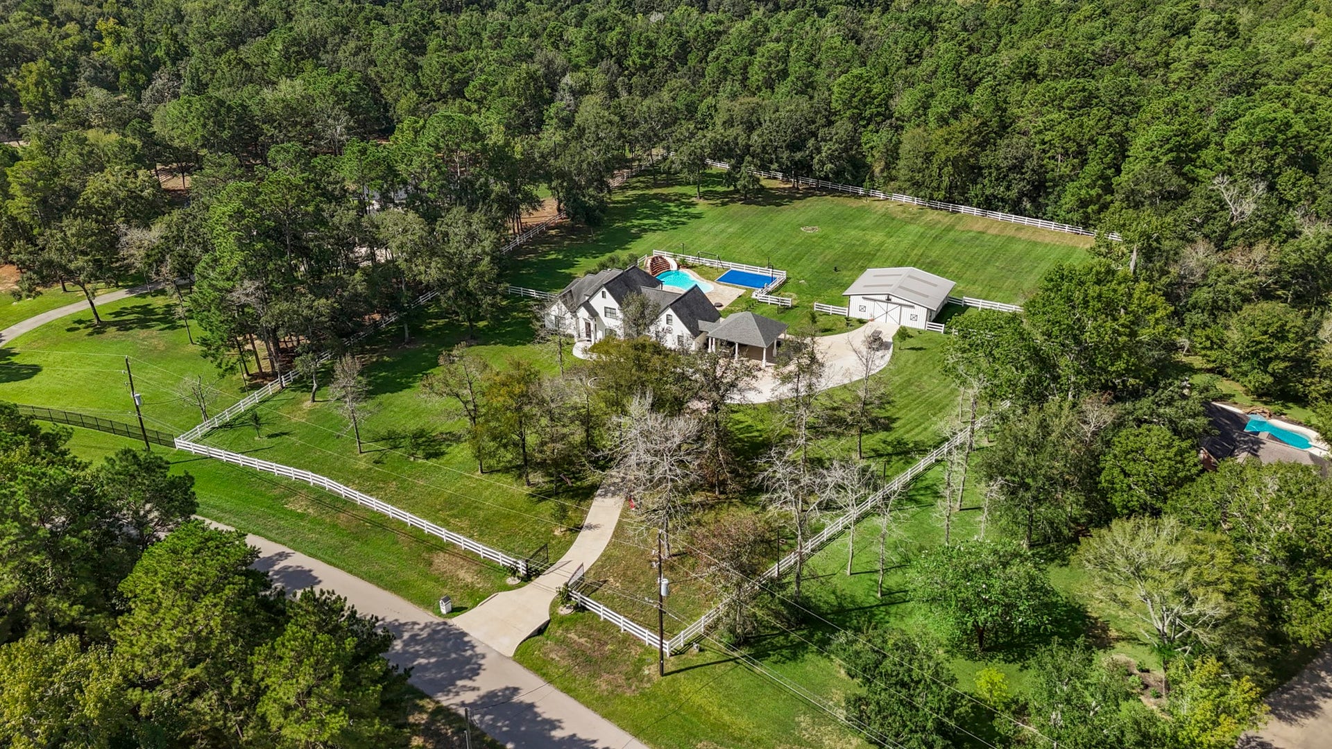 31219 Edgewater Drive, Magnolia, TX 77354 An aerial view traces the driveway through the trees toward the home.