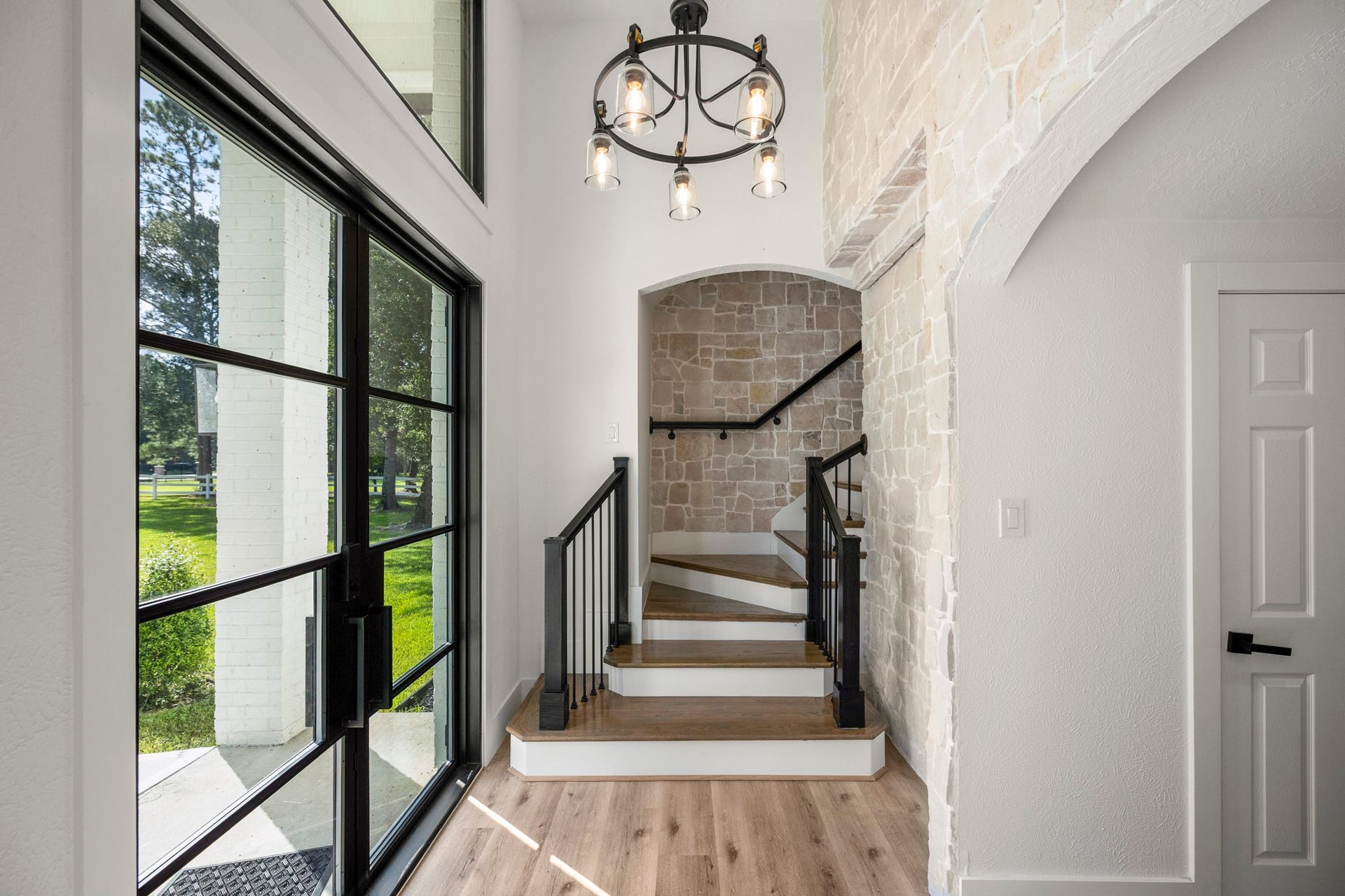 31219 Edgewater Drive, Magnolia, TX 77354 Oversized iron doors and large windows allow light to pour into the home's entry.