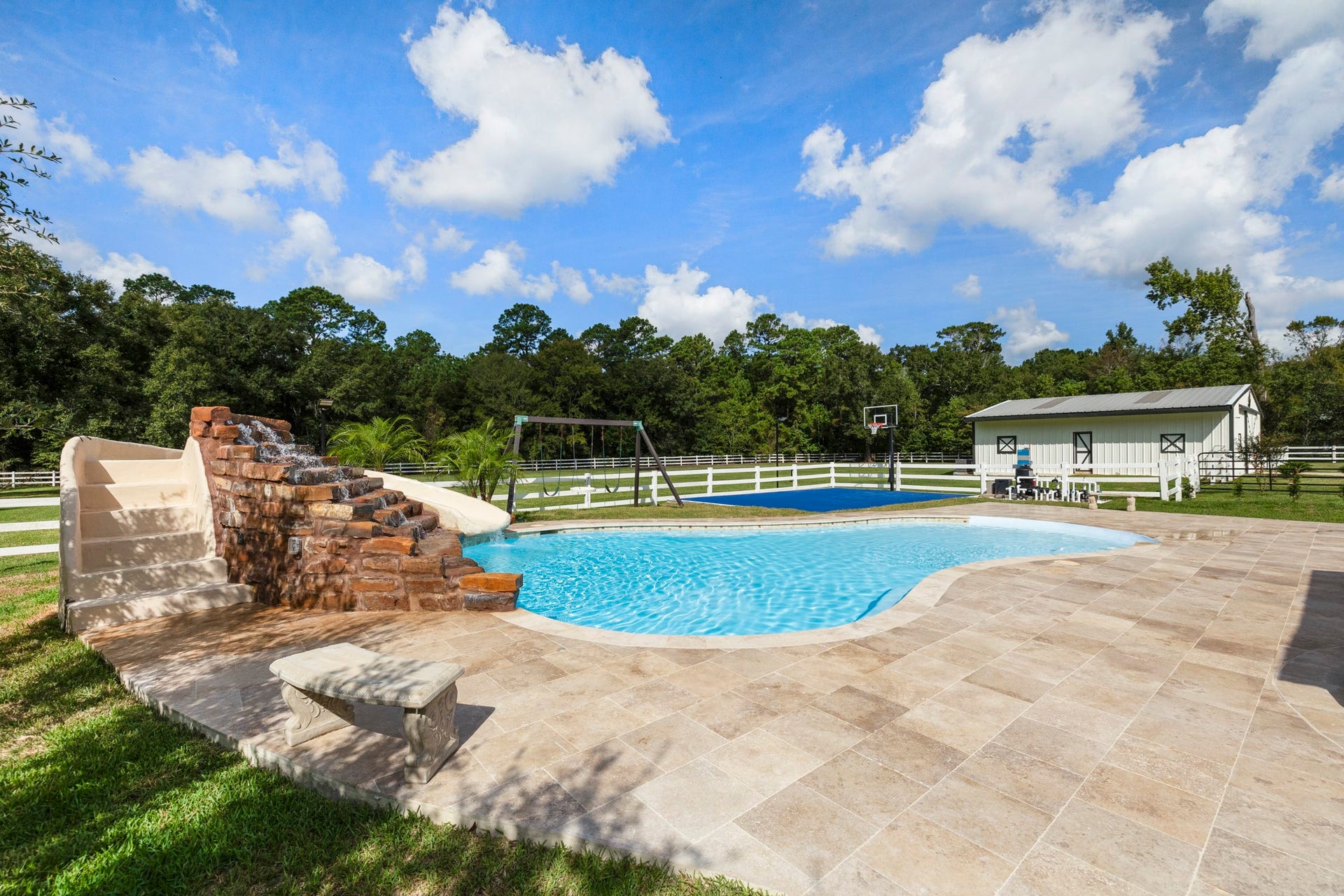 31219 Edgewater Drive, Magnolia, TX 77354 The pool is surrounded by a broad patio, with open grounds extending beyond.